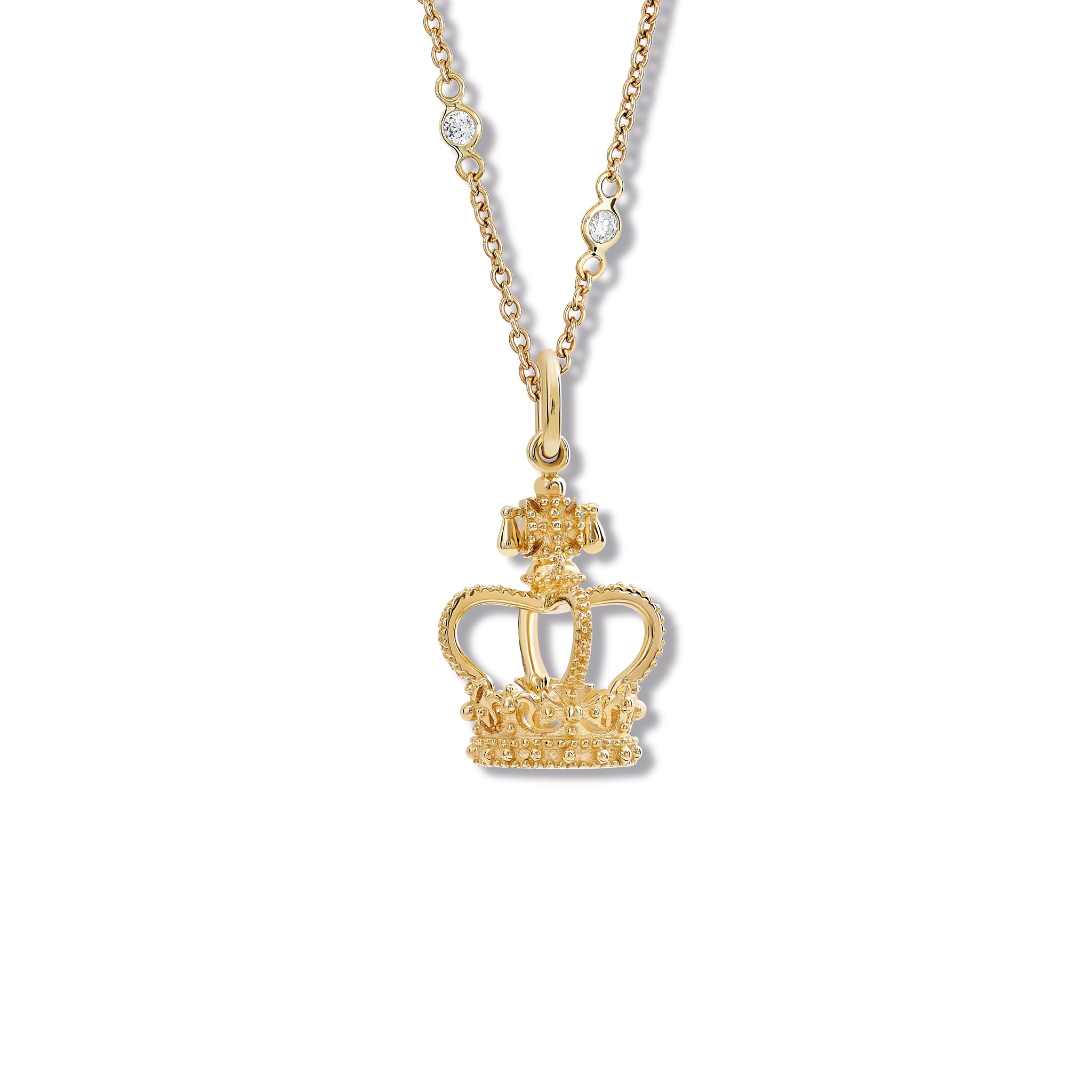 A crown-shaped necklace pendant in precious metal, hanging from a necklace chain.