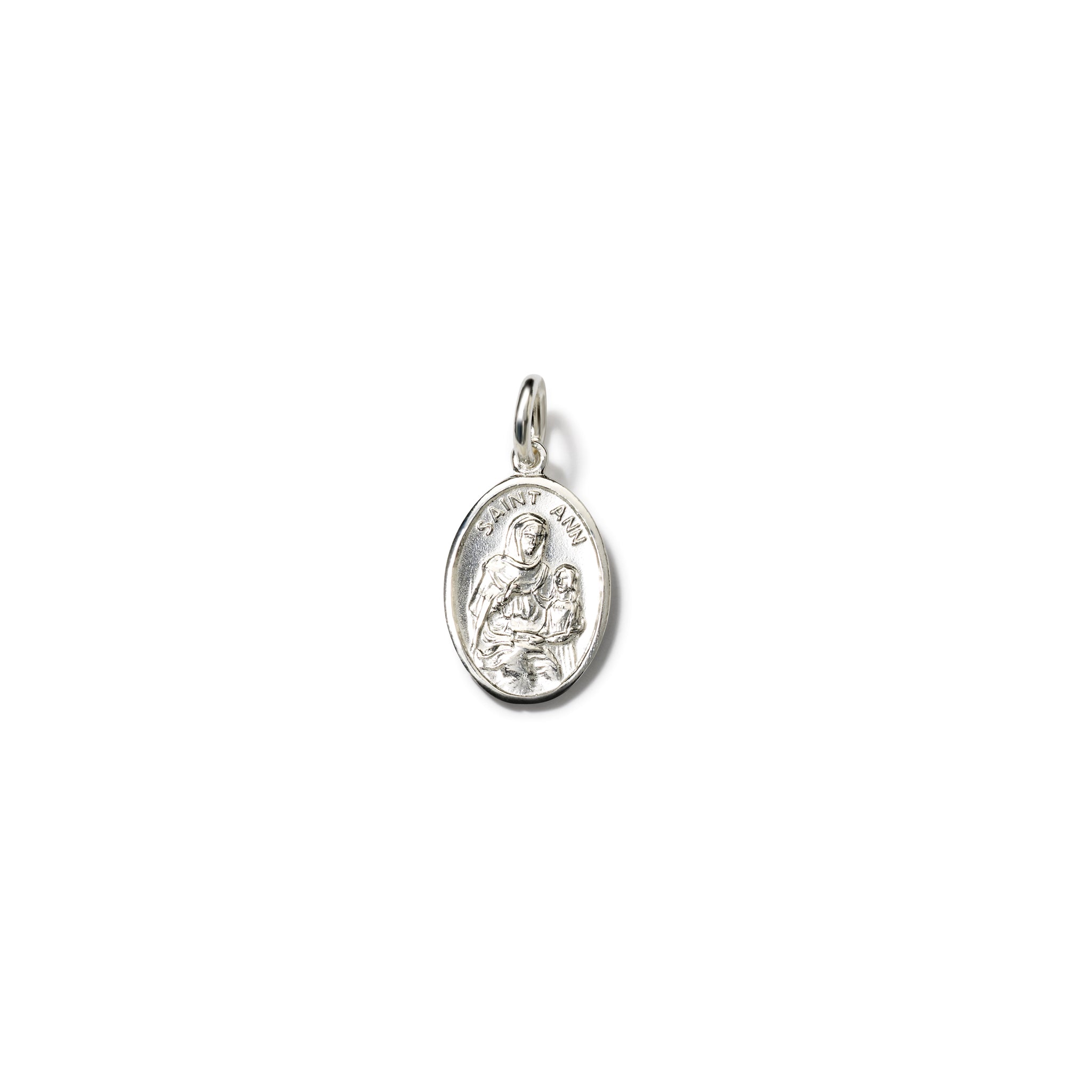 Handcrafted oval sterling silver pendant with an engraving of  Saint Anne cradling a child and 'Saint Anne' inscribed above. Includes a top loop for chain attachment