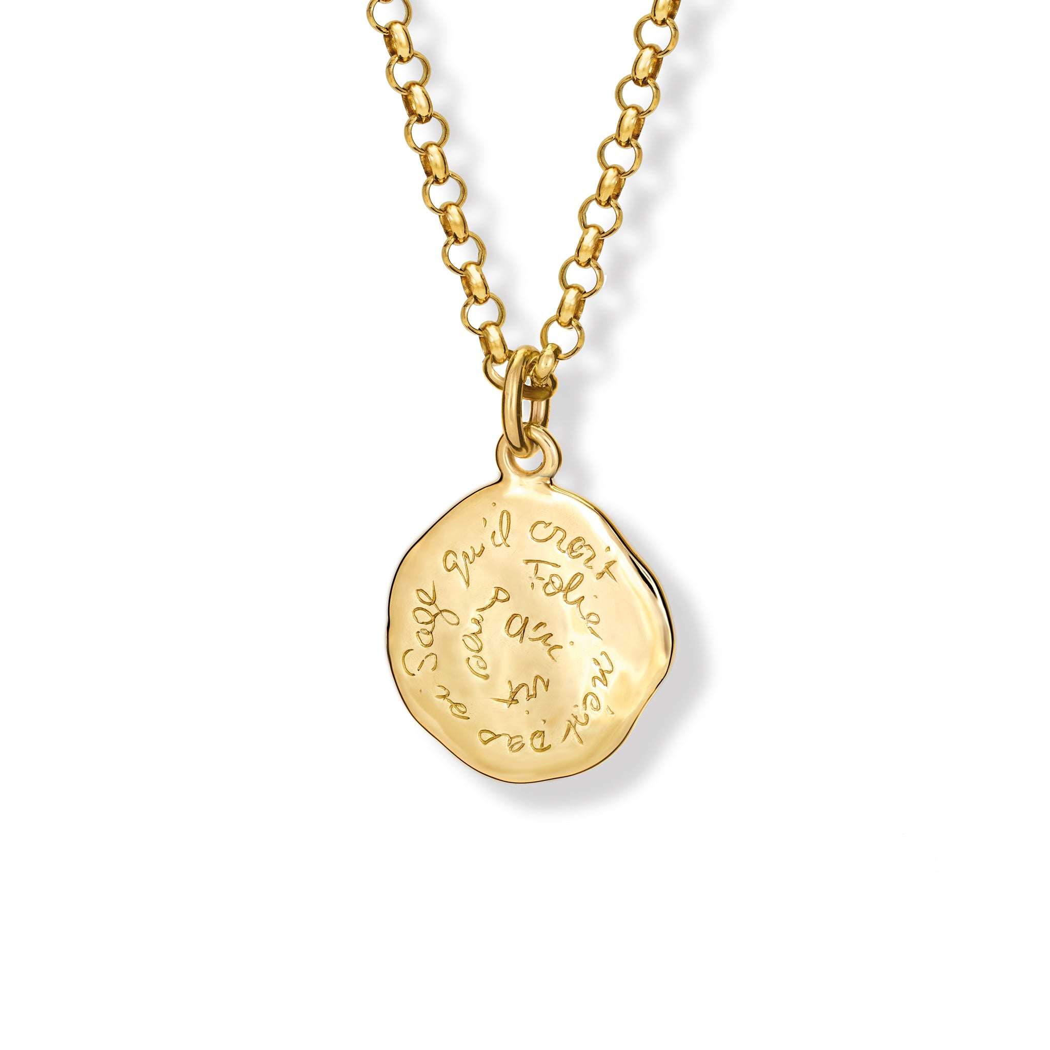 A handcrafted necklace pendant in precious metal featuring engraved text.