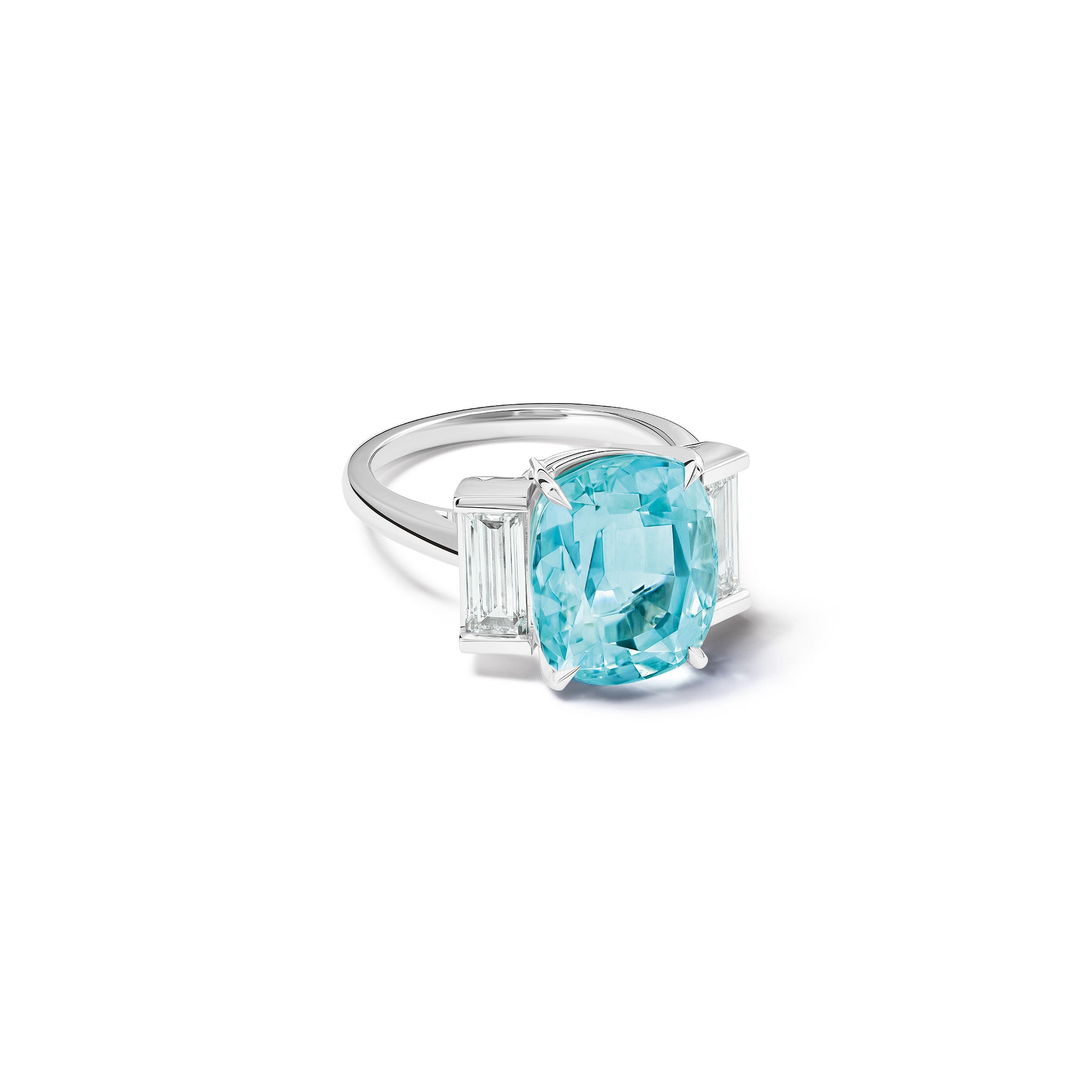 Handcrafted 18ct white gold engagement ring featuring a central oval blue aquamarine flanked by two smaller rectangular diamonds on each side, all set in a sleek band.