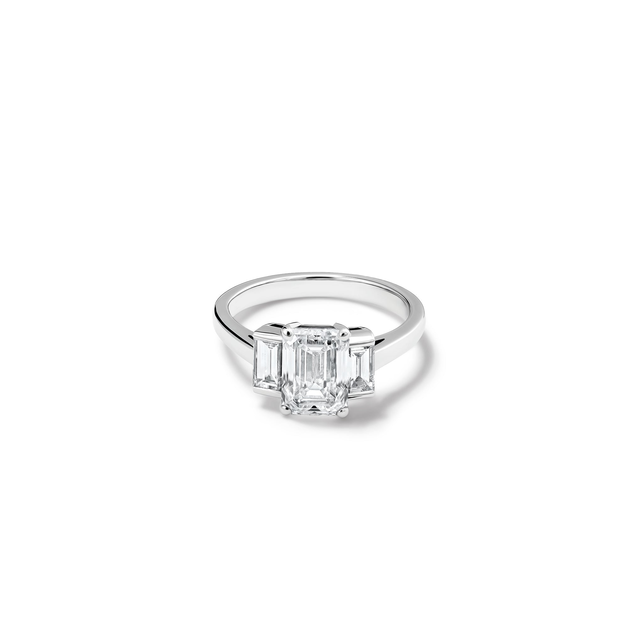 Handcrafted platinum engagement ring featuring a central rectangular diamond flanked by two smaller rectangular diamonds on each side, all set in a sleek band.