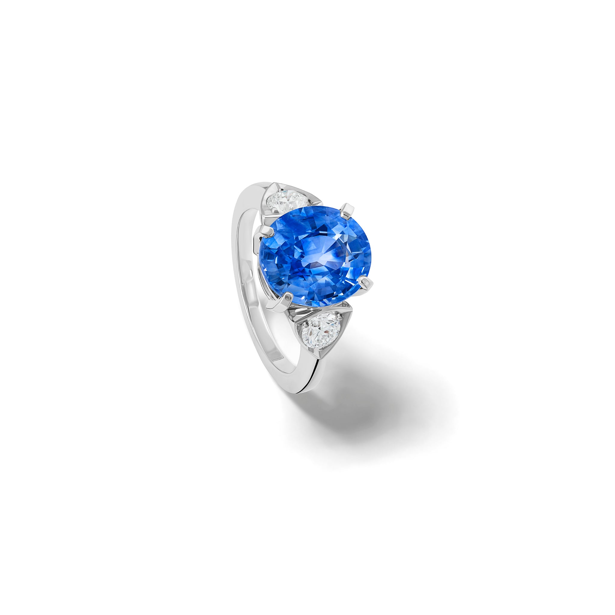 Handcrafted 18ct white gold engagement ring featuring a large central oval sapphire flanked by one smaller teardrop-shaped diamond on each side.