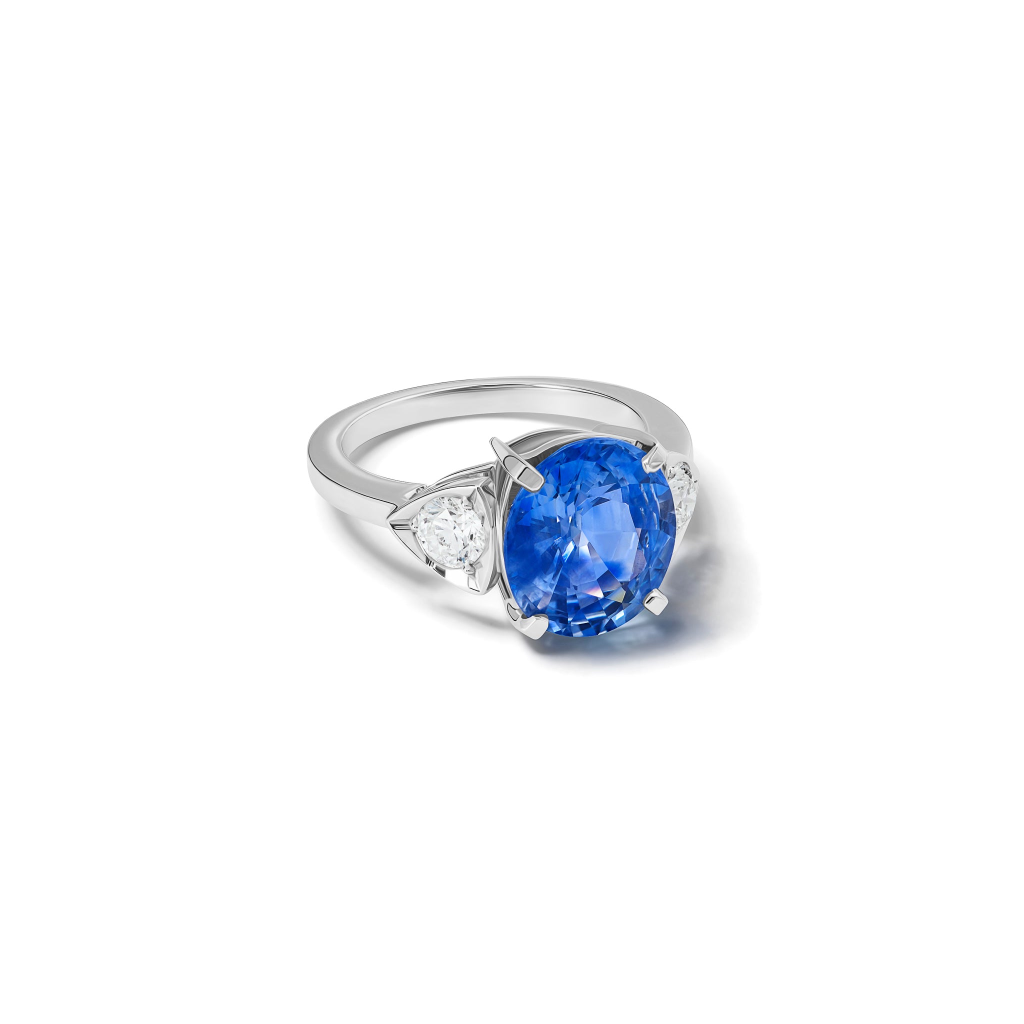 Handcrafted 18ct white gold engagement ring featuring a large central oval sapphire flanked by one smaller teardrop-shaped diamond on each side.