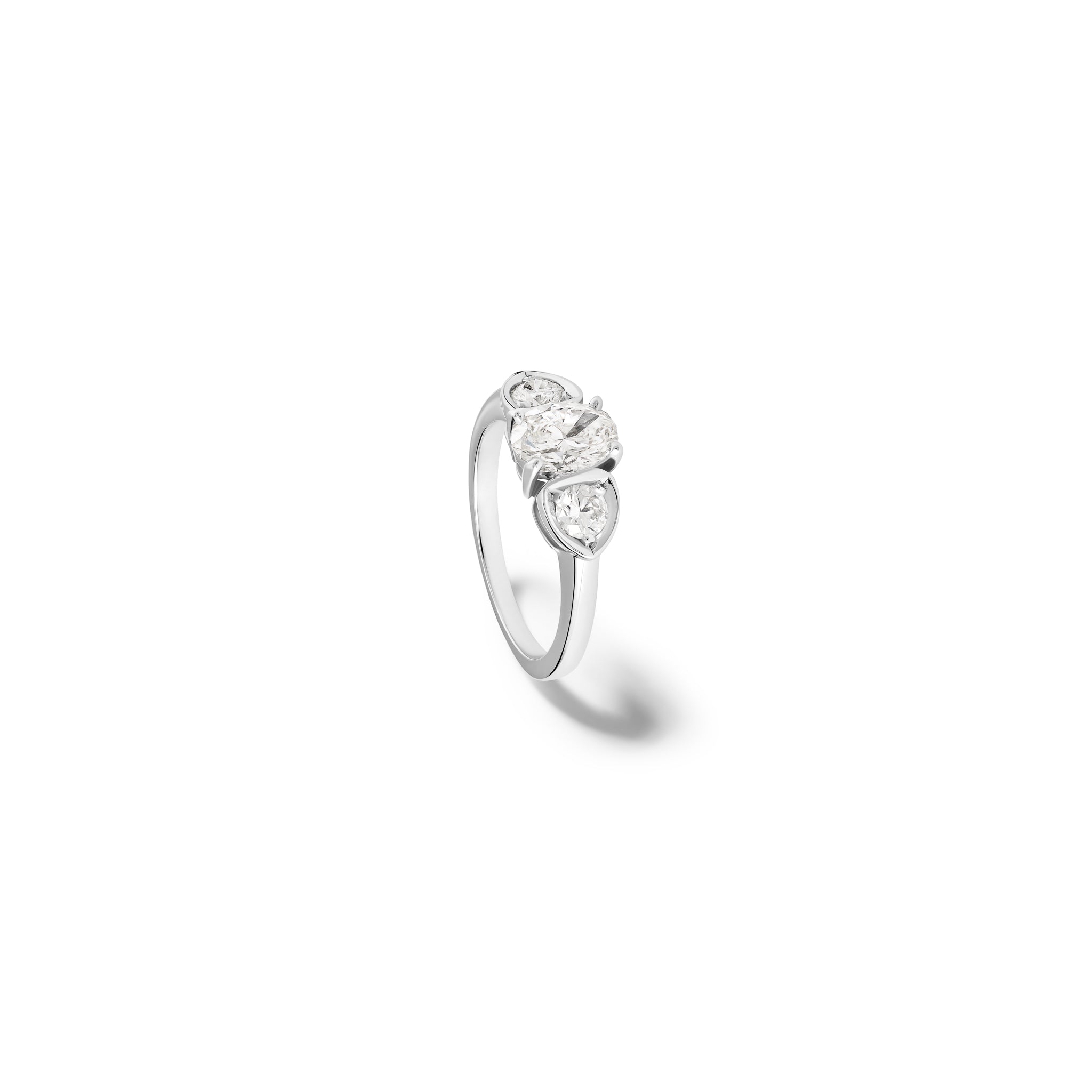 Handcrafted 18ct white gold engagement ring featuring a large central oval diamond flanked by one smaller teardrop-shaped diamond on each side.