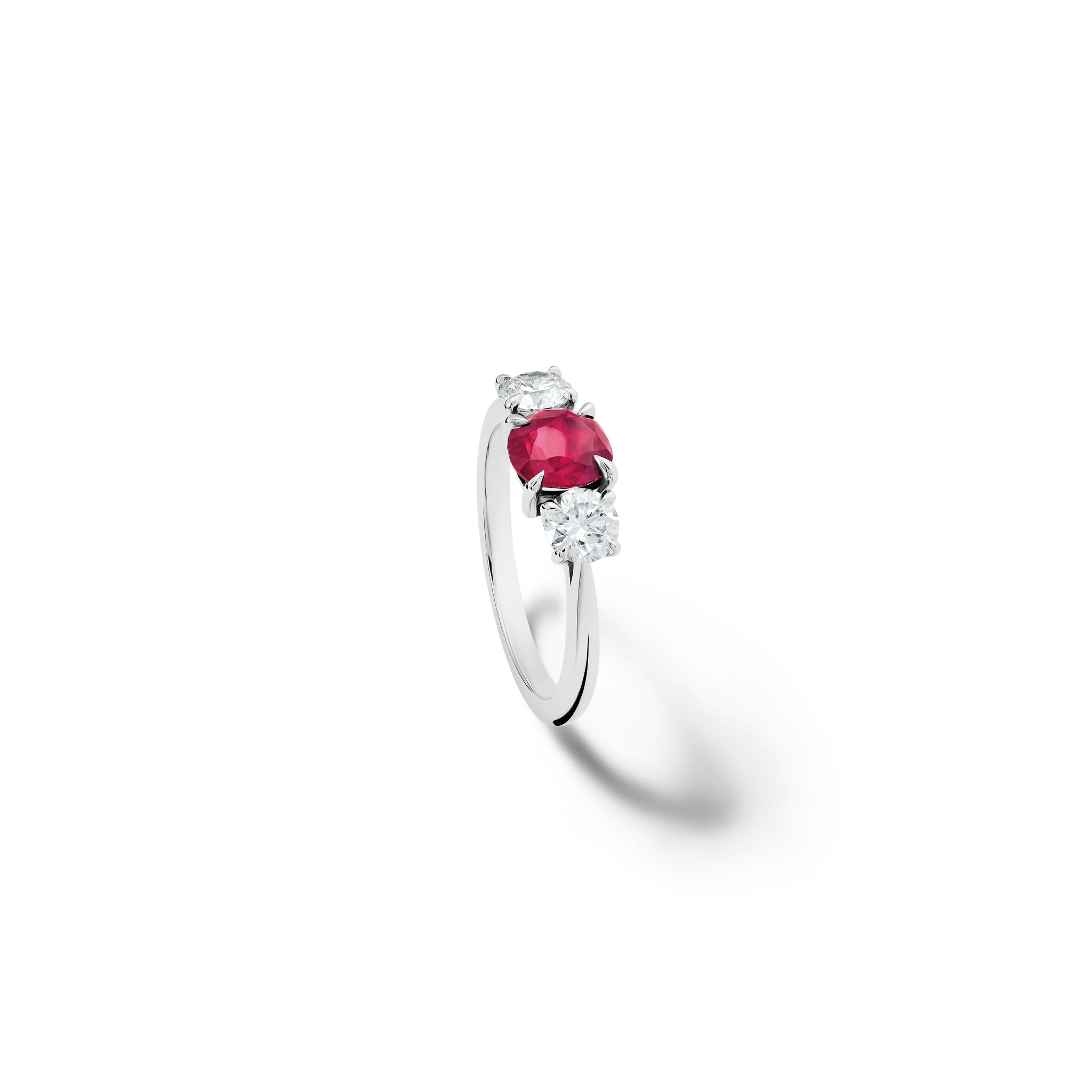 Handcrafted 18ct white gold engagement ring featuring a large, oval ruby at its centre, surrounded by two smaller teardrop-shaped white diamonds.