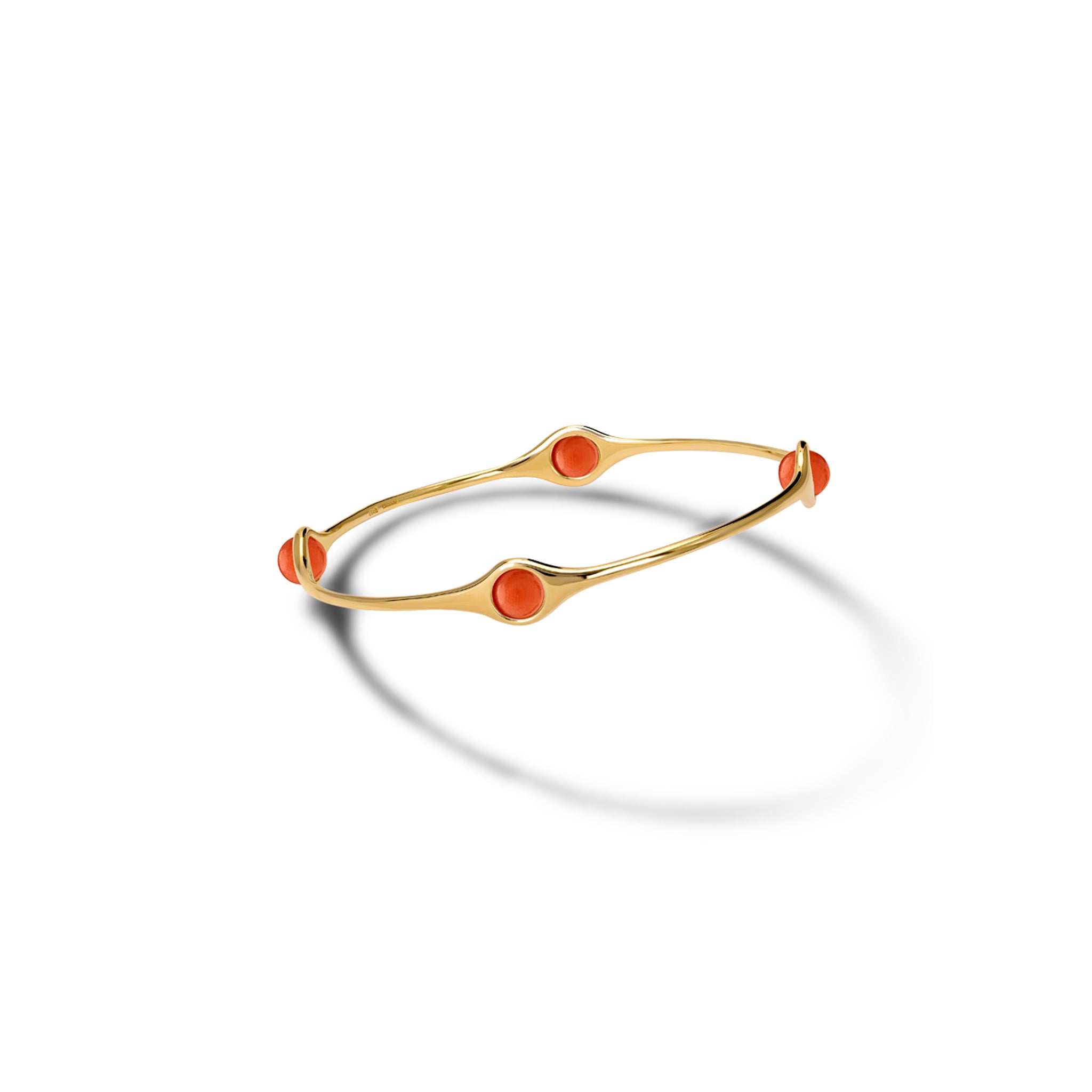 Handcrafted yellow gold bangle featuring four coral beads.