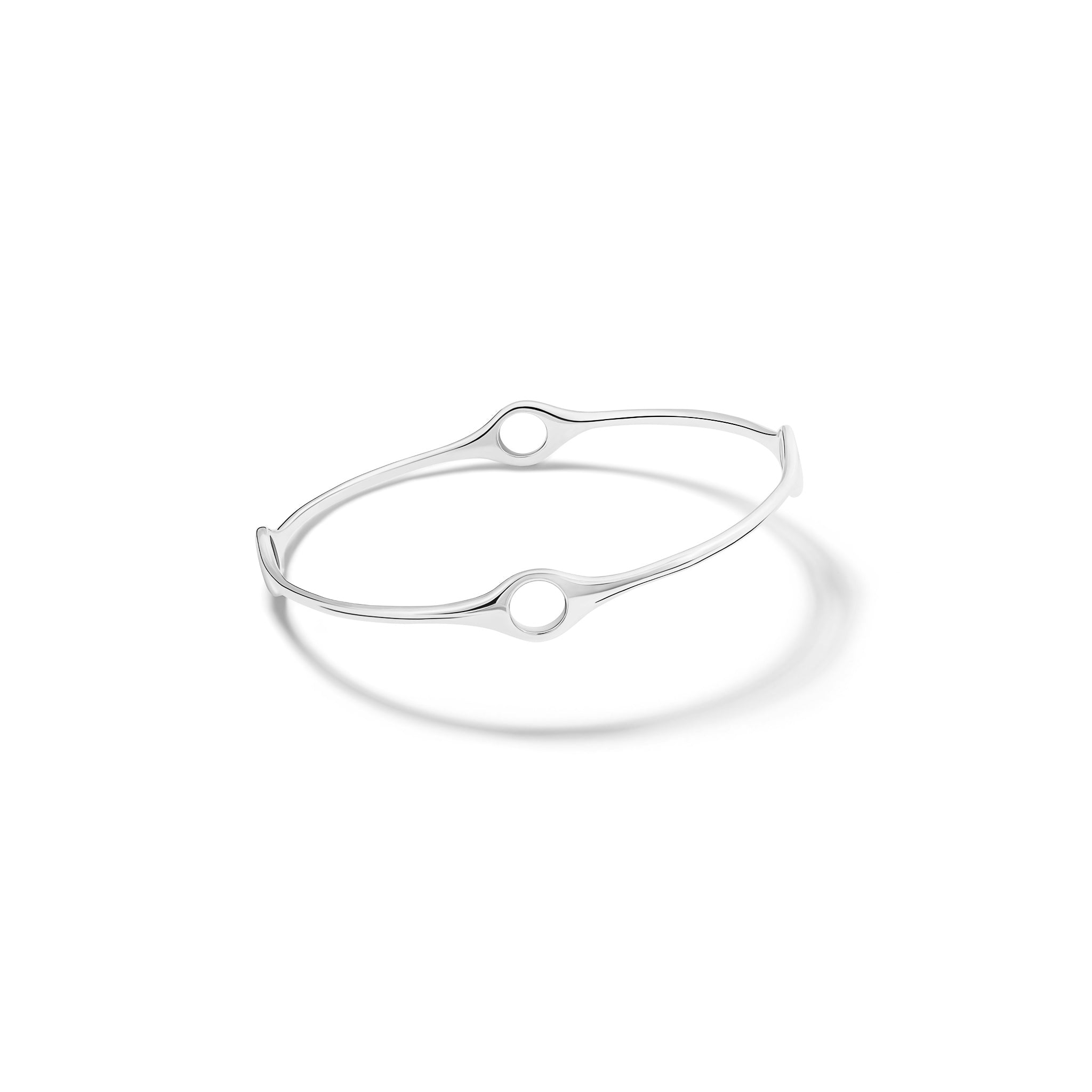 Handcrafted sterling silver bangle with four circular spaces.