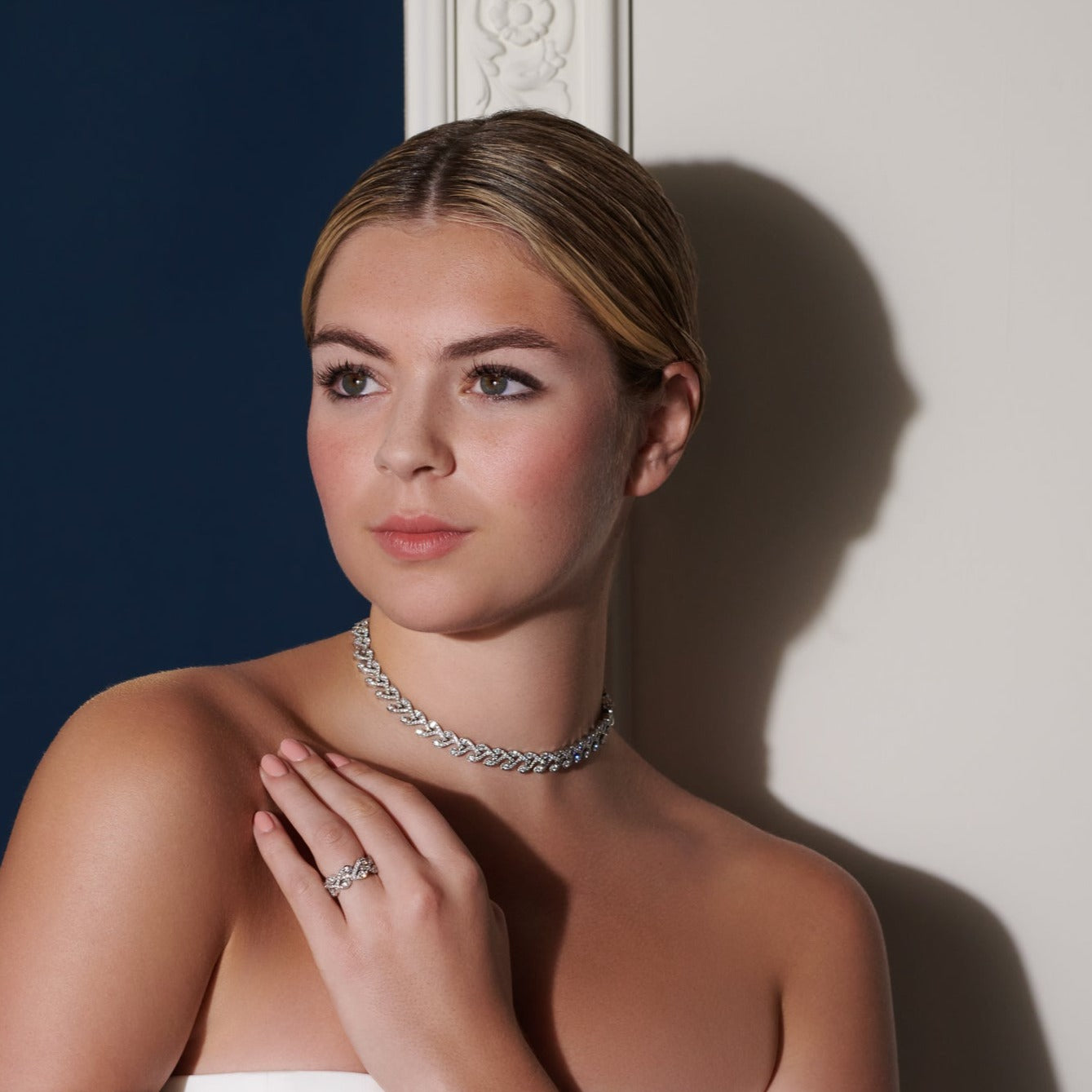 Model wearing a handcrafted 18ct white gold necklace featuring a rosemary shape with diamonds.
