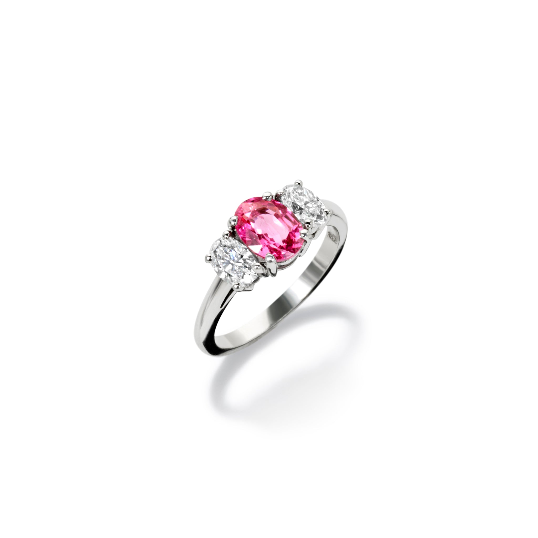 Handcrafted 18ct white gold engagement engagement ring with a large central pink sapphire flanked by two slightly smaller diamonds on each side.