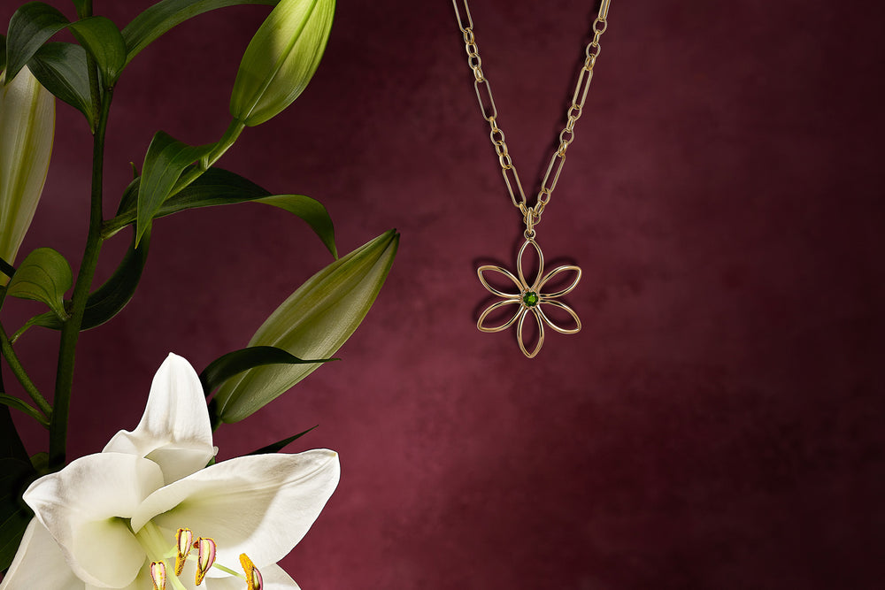 Handcrafted yellow gold flower shaped necklace pendant featuring a chrome diopside precious gemstone at the centre.