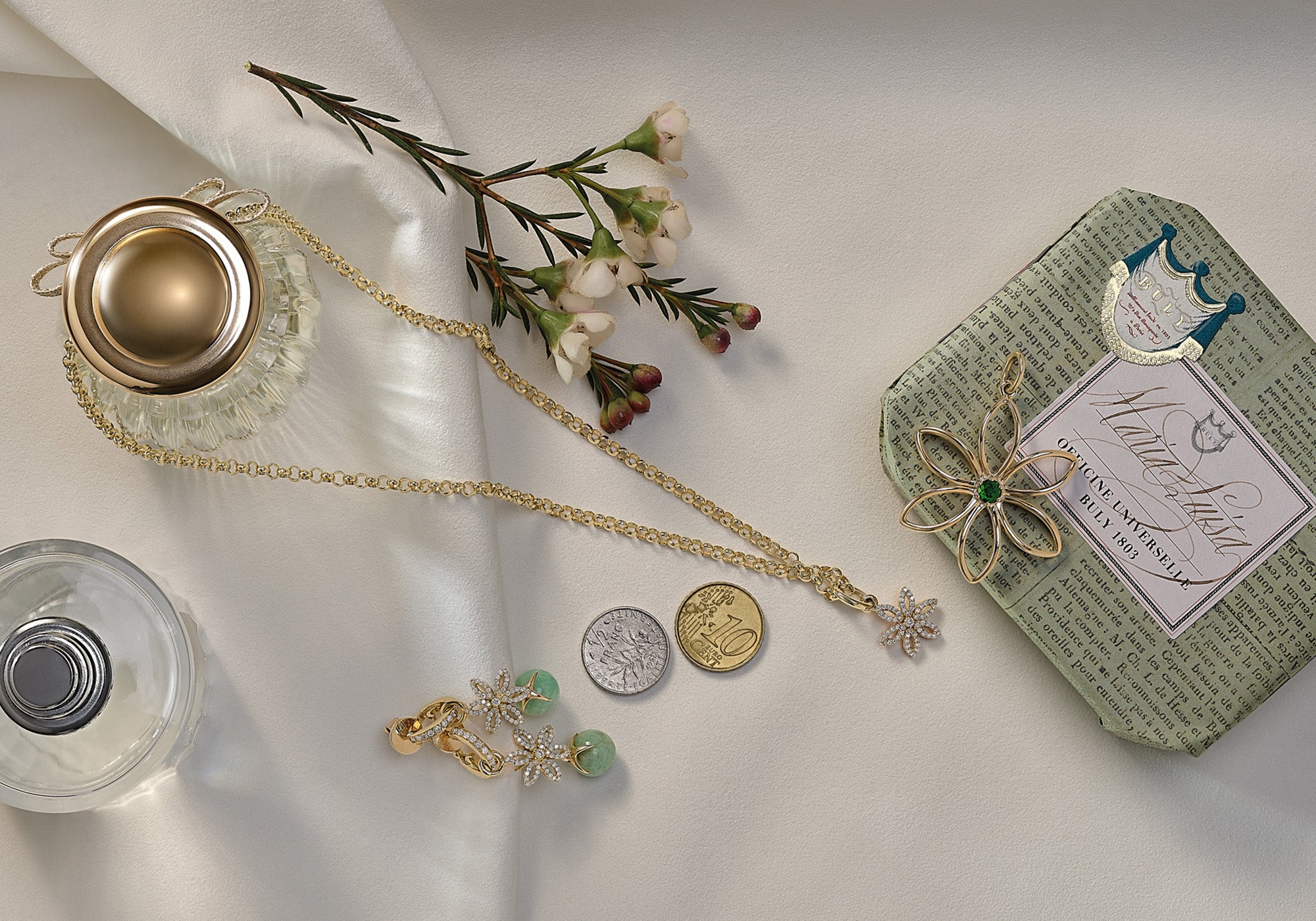 handcrafted yellow gold necklace pendants surrounded by care products