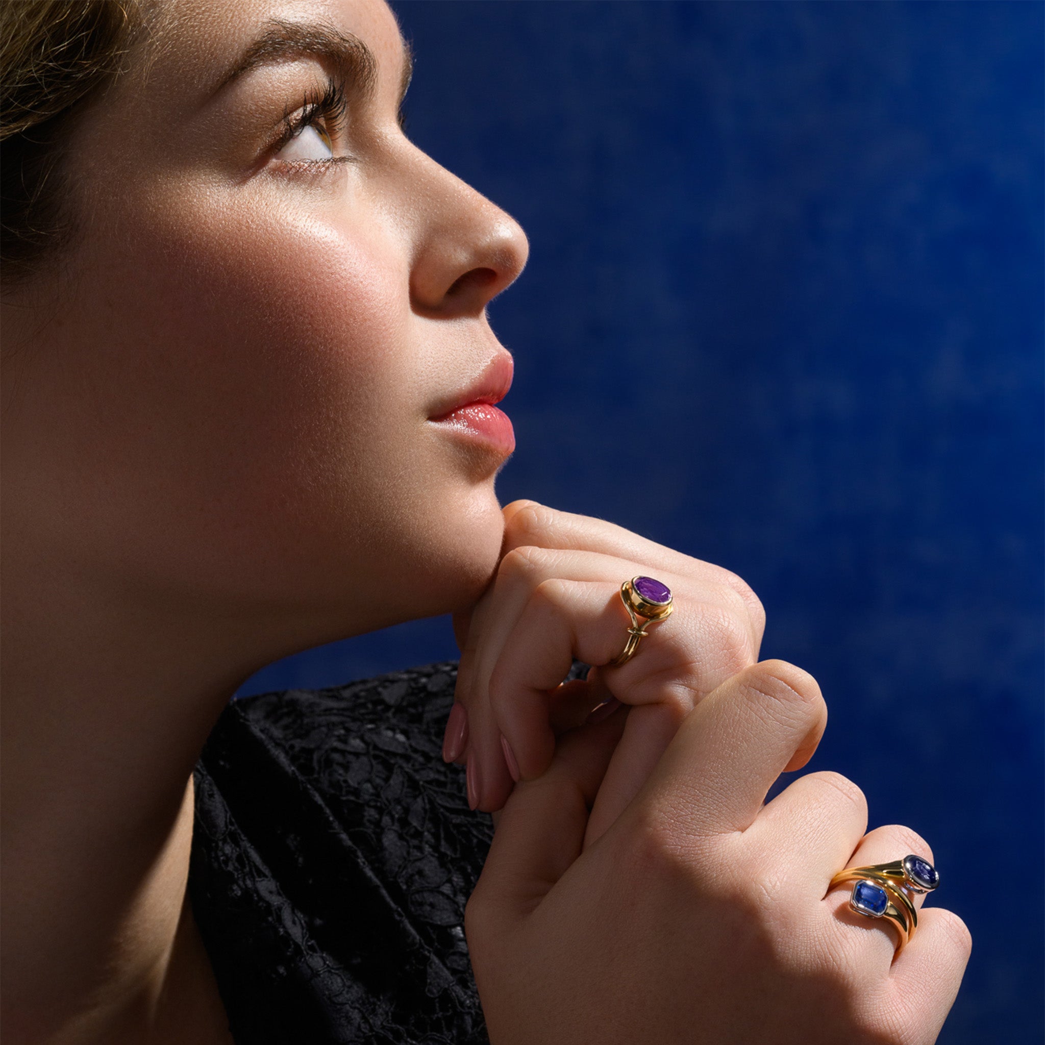 Model wearing a handcrafted yellow gold signet ring featuring a smooth, round central disc of a gemstone with sleek, curved band accents.