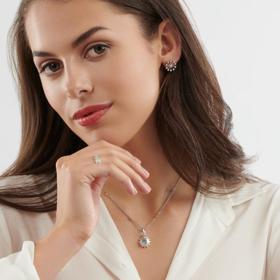 Model wearing a handcrafted sunflower necklace pendant in precious metal featuring a central precious stone.