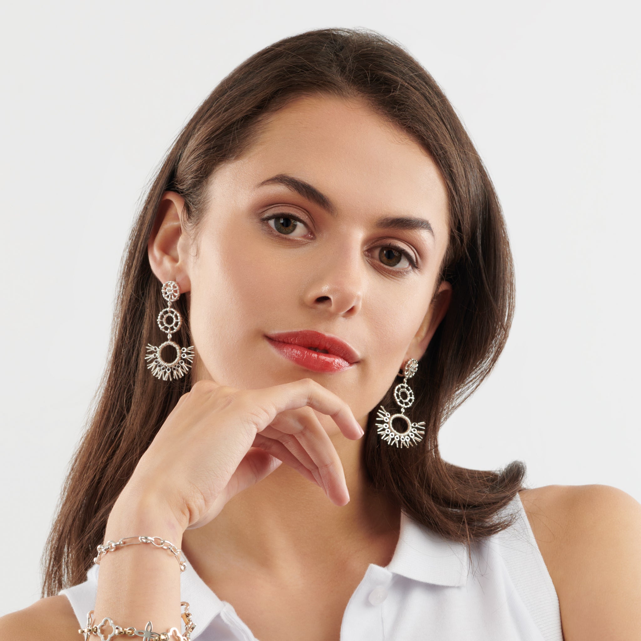 Model wearing handcrafted sterling silver earrings in the shape of dried palm fronds from Morocco.
