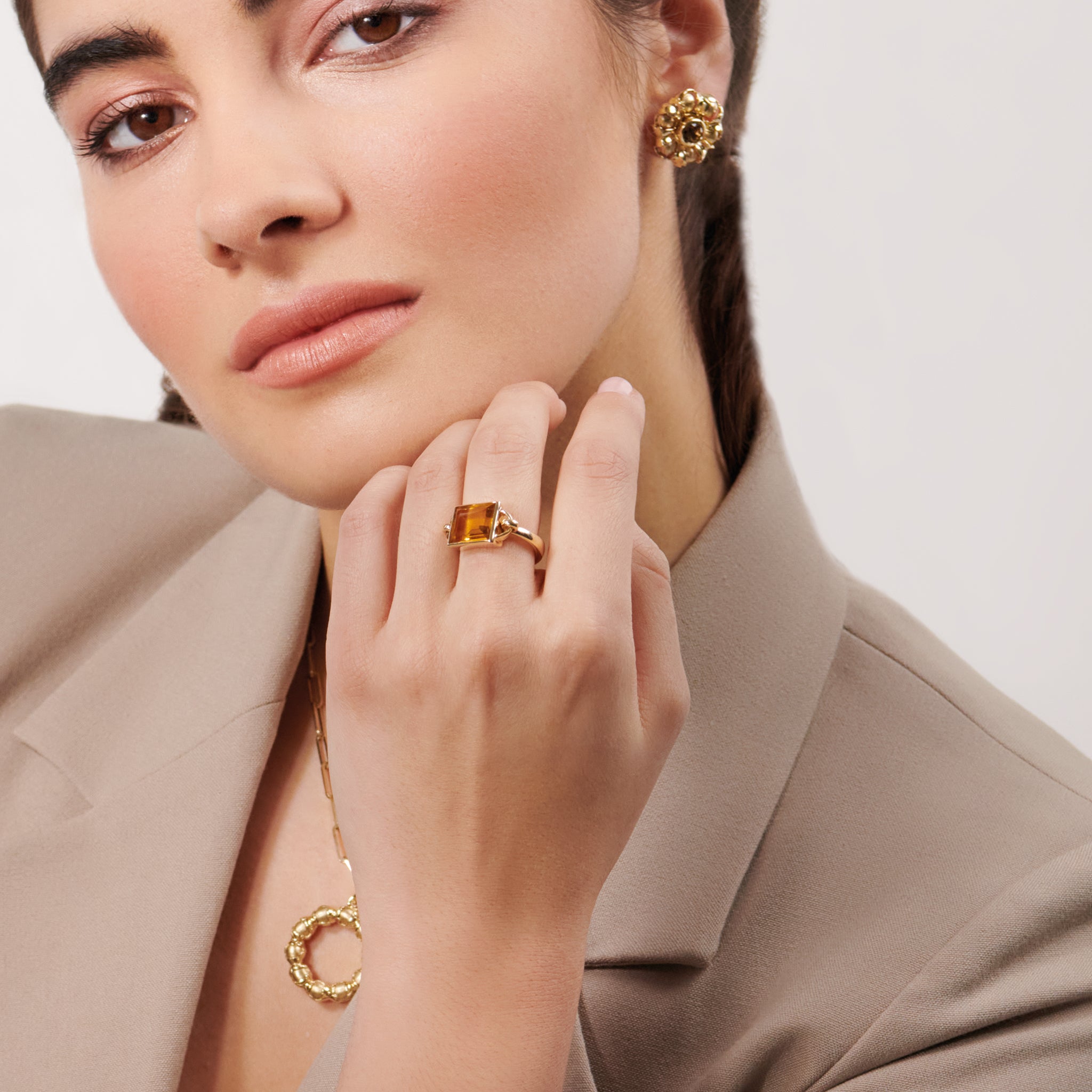 Model wearing a handcrafted yellow gold ring featuring a central citrine, birthstone of November.