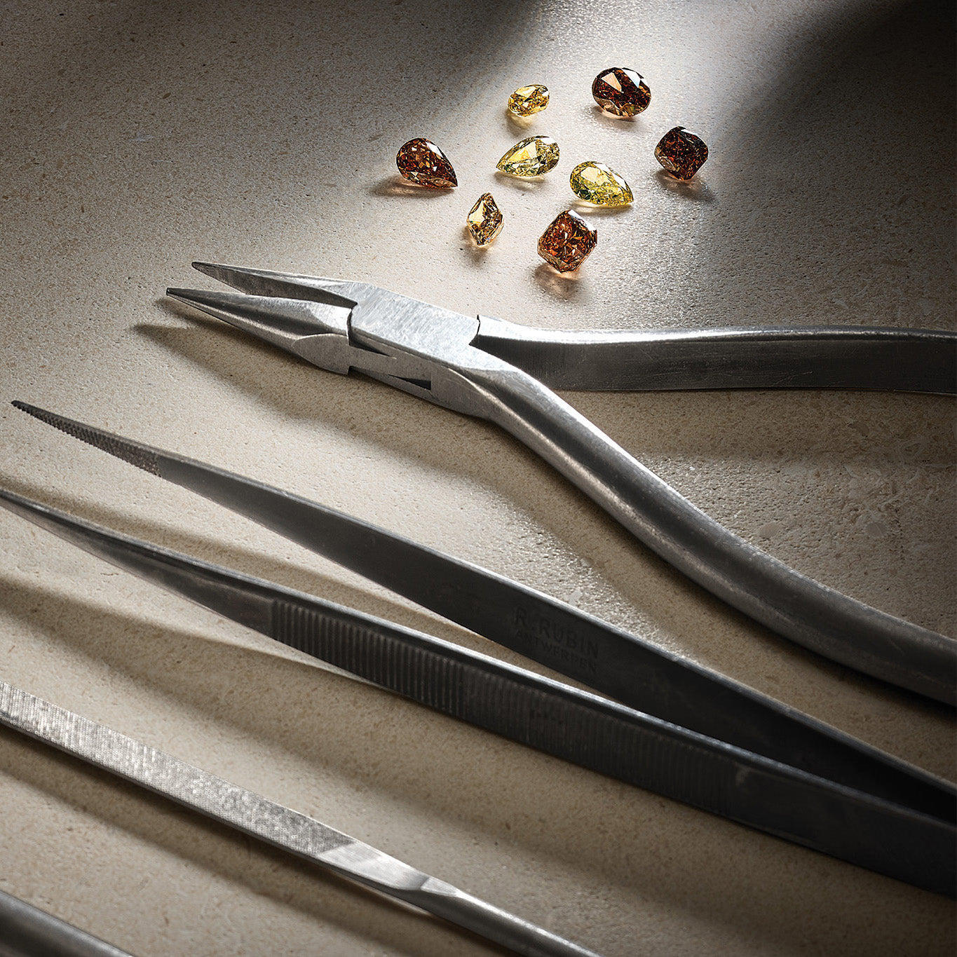 Jewellery tools next to brown and yellow precious stones