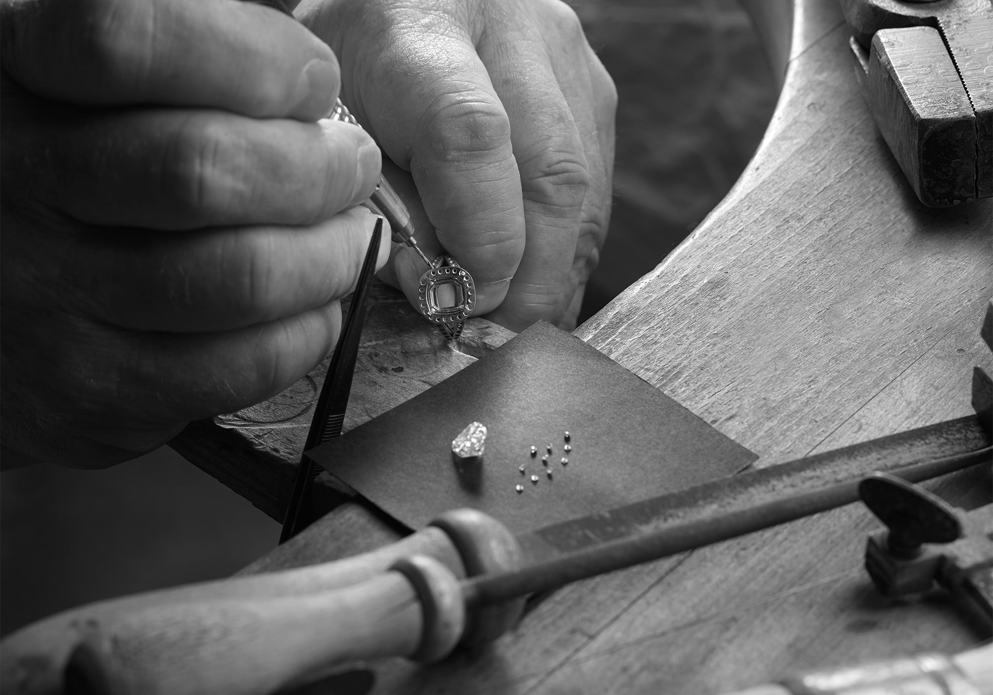 A jeweller setting a handcrafted ring with diamonds.