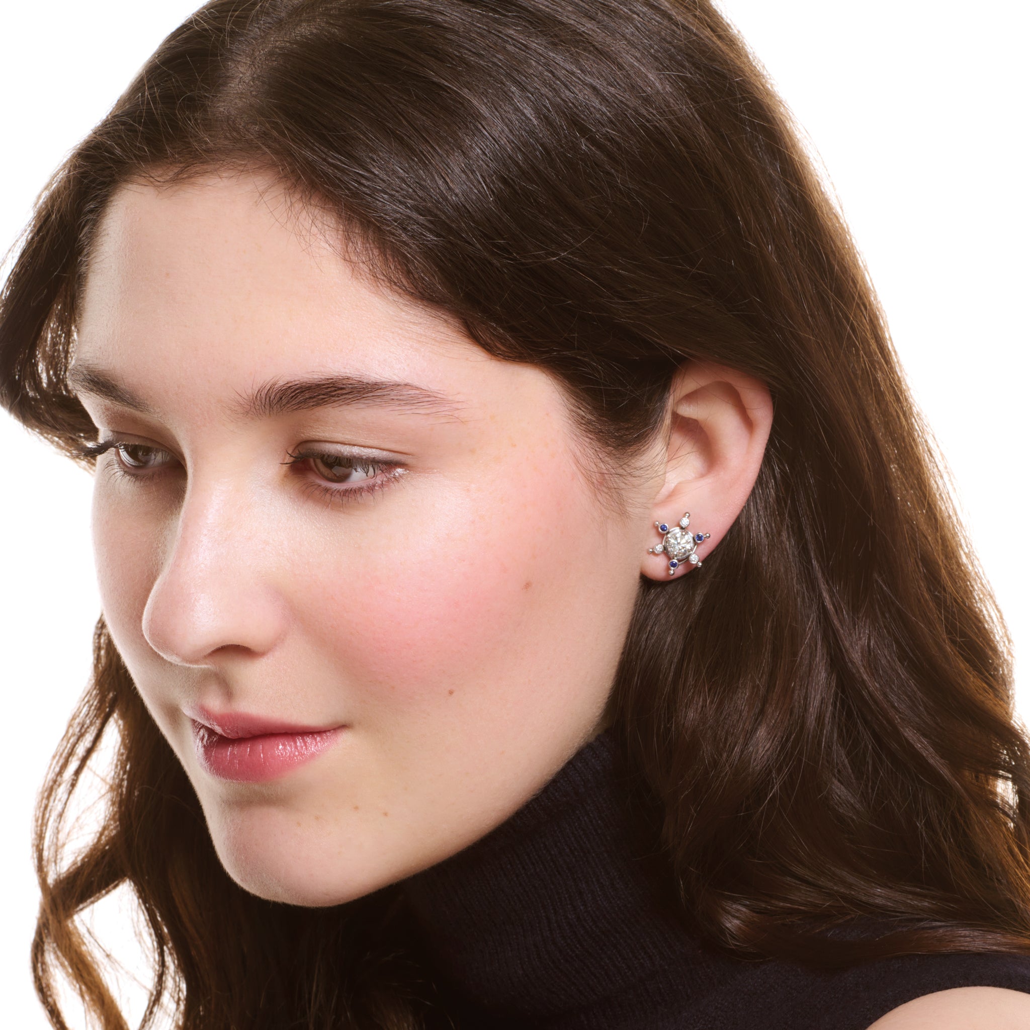 Model wearing handcrafted white gold earring halos inspired by a cactus, featuring six prongs, set small sapphires and diamonds.