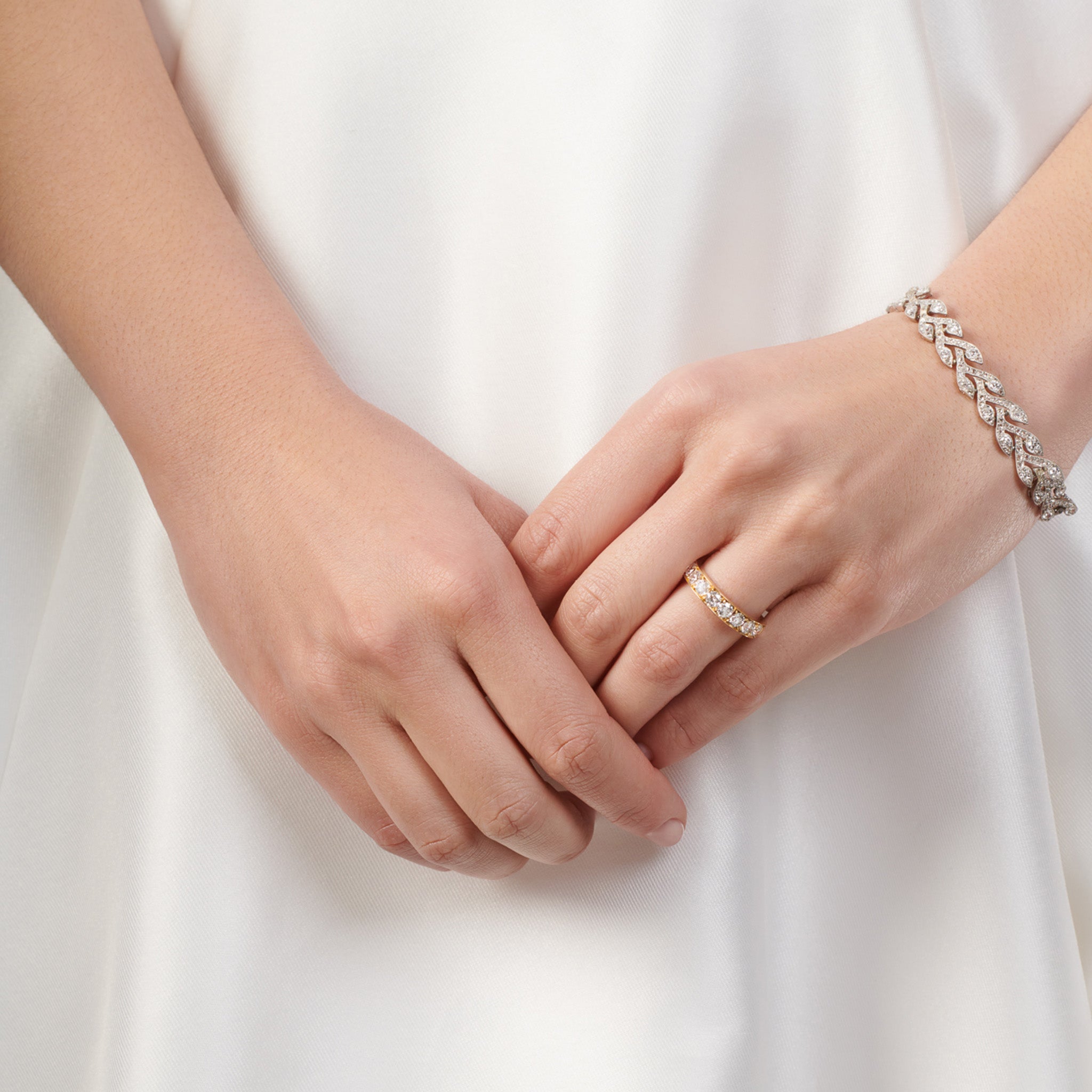 Model wearing a handcrafted 18ct yellow gold wedding band set with diamonds along half of the band.