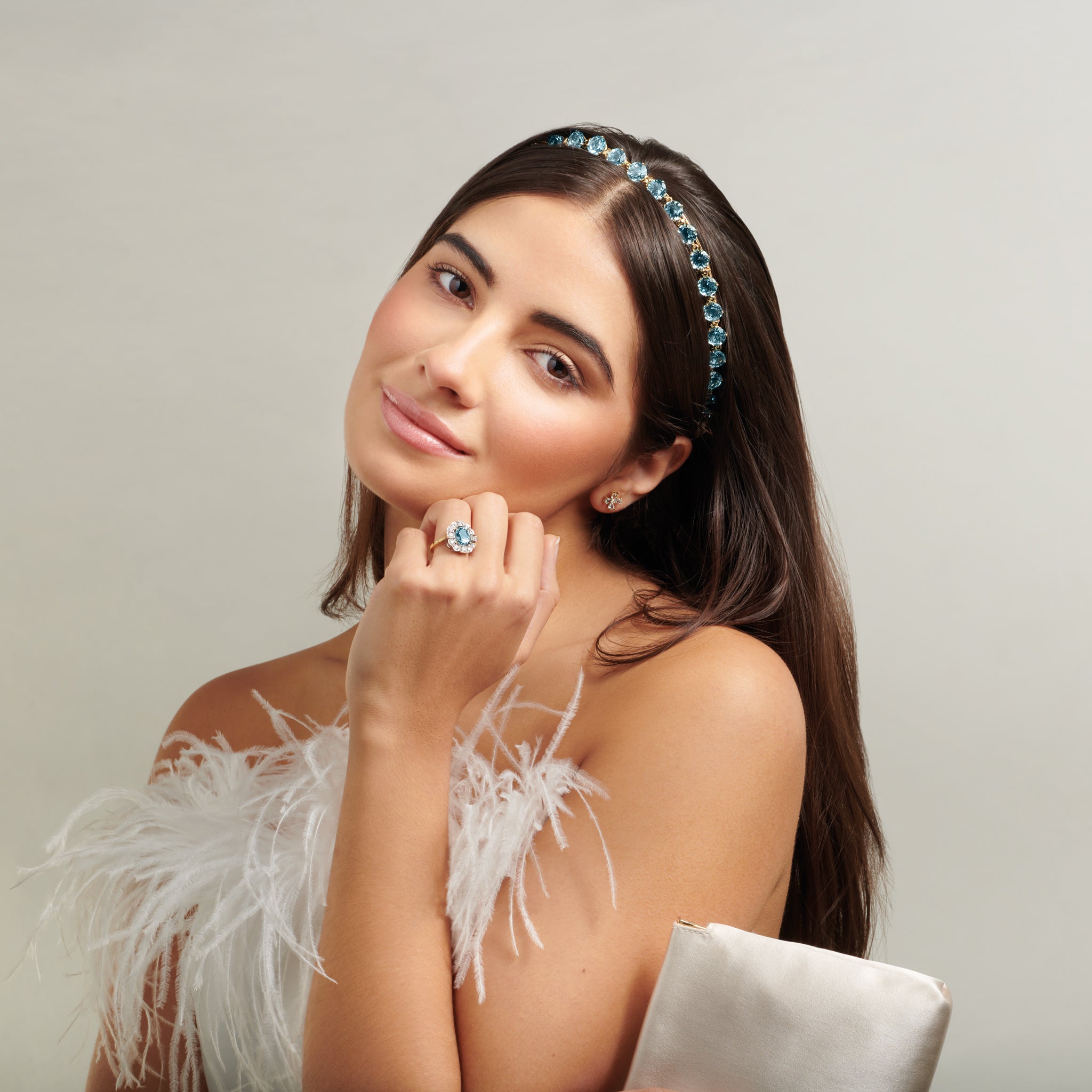 Model wearing a handcrafted yellow gold tiara featuring circular blue topaz gemstones.
