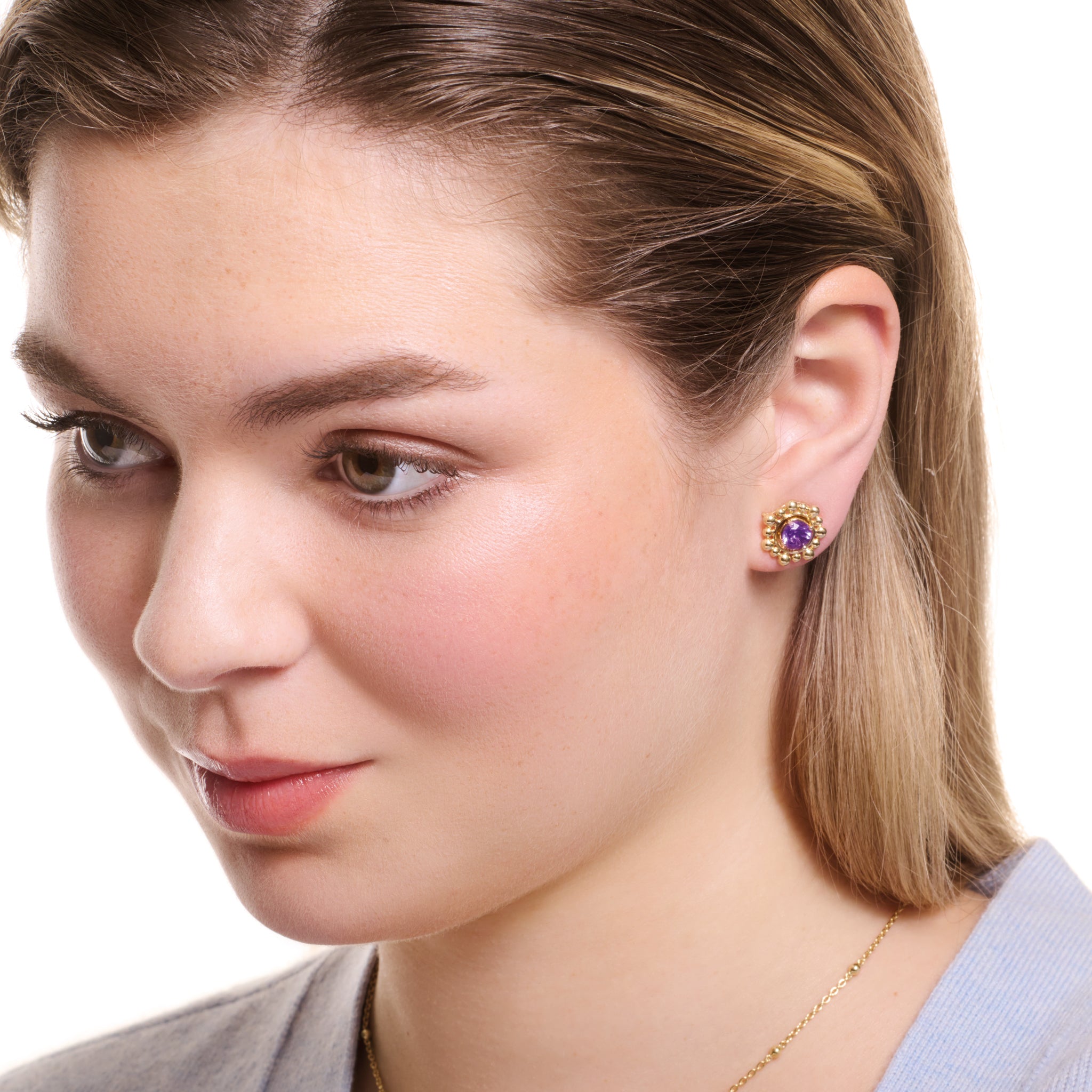 Model wearing handcrafted yellow gold earring halos adorned with closely spaced circular beads.