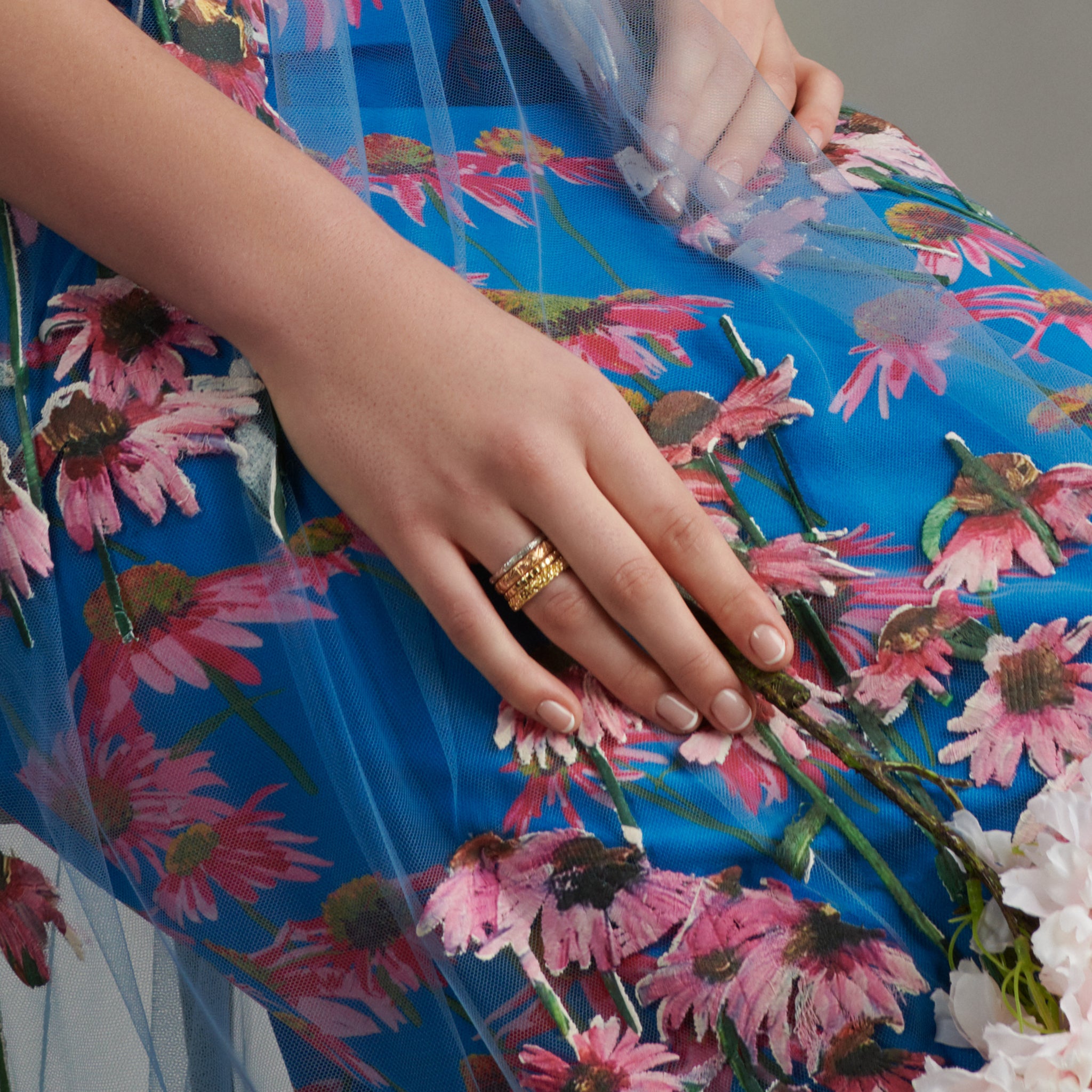 Model wearing a handcrafted 18ct yellow gold ring featuring the four seasonal depictions in Japan.