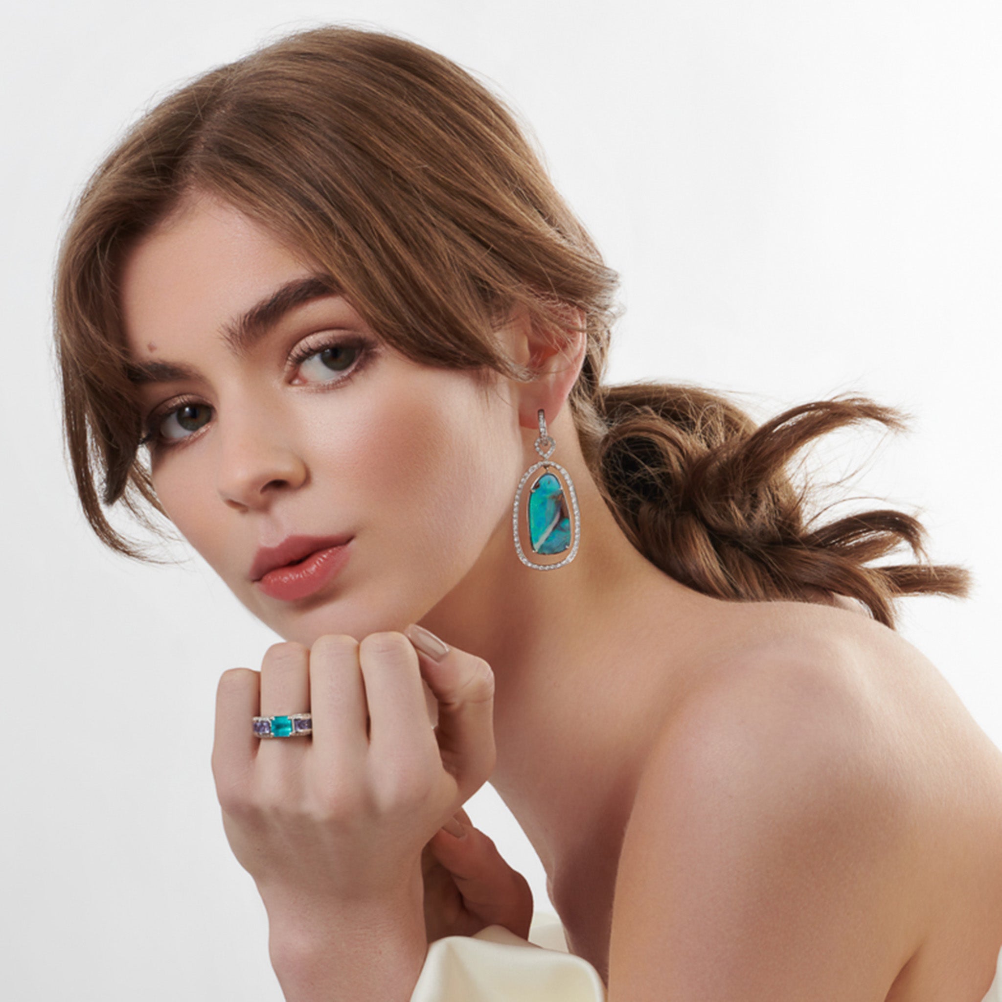 Model wearing handcrafted 18ct white gold earring drops featuring teardrop-shaped opals with diamonds, birthstone of October.