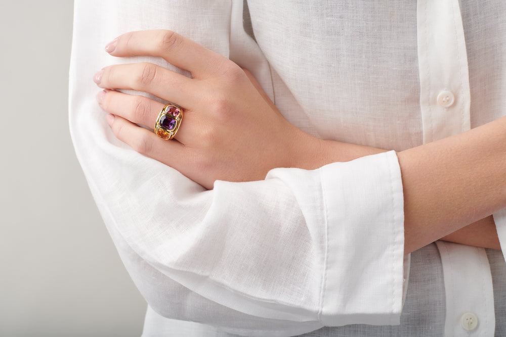 Model wearing a handcrafted yellow gold ring featuring a facetted tourmaline, birthstone of October.