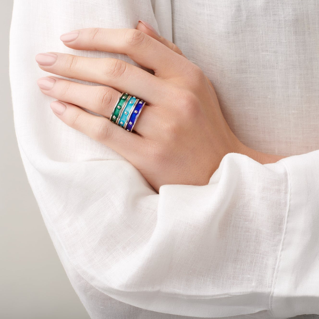 Model wearing handcrafted sterling silver rings with evenly spaced, protruding round dots with enamel.