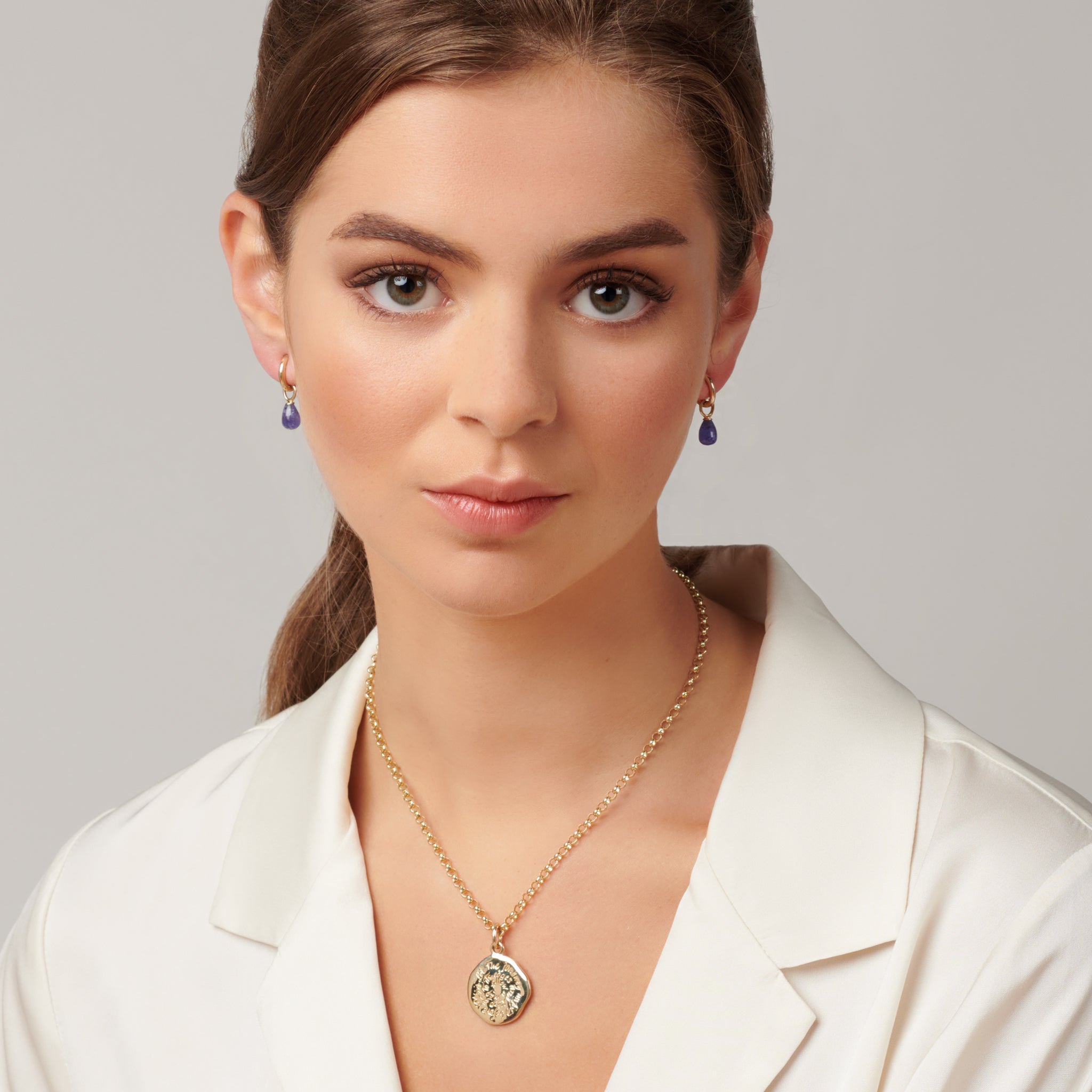 Model wearing a handcrafted round 18ct yellow gold necklace pendant engraved with a quote.