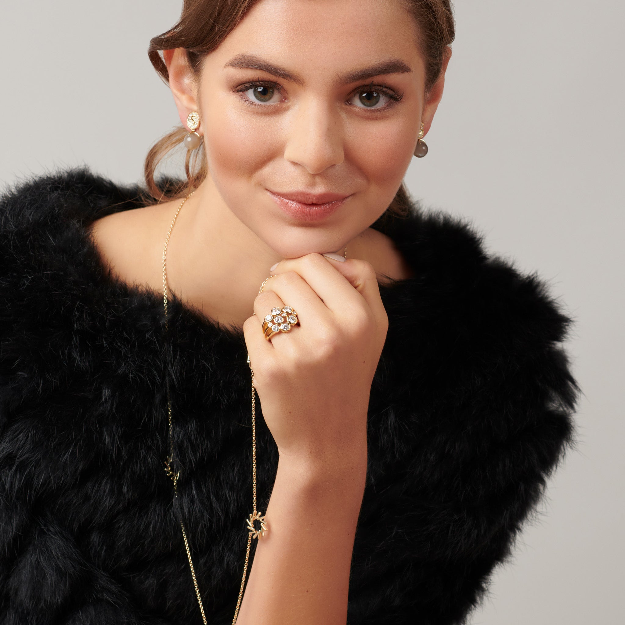 Model wearing a handcrafted 18ct yellow gold ring featuring different sized round diamonds. 