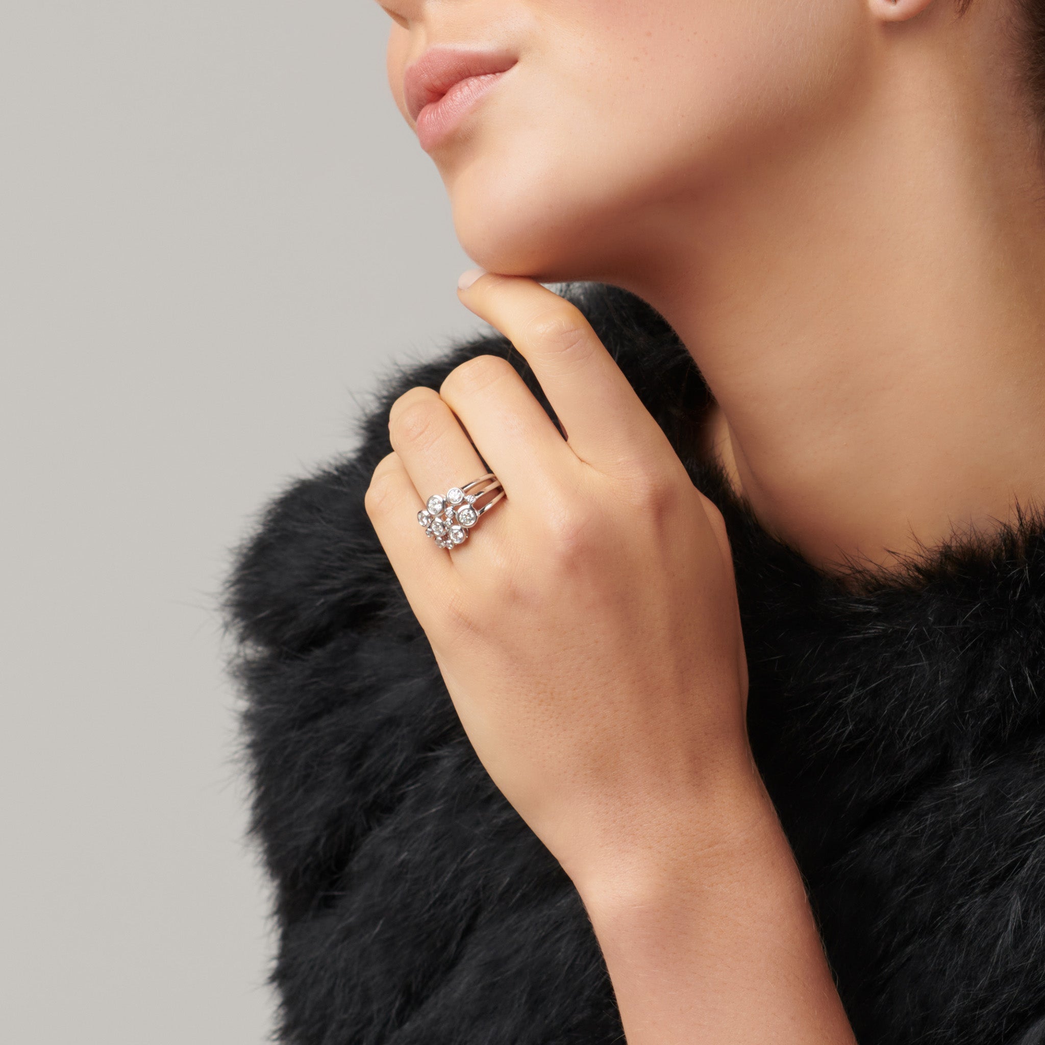 Model wearing a handcrafted 18ct white gold ring featuring different sized round diamonds.