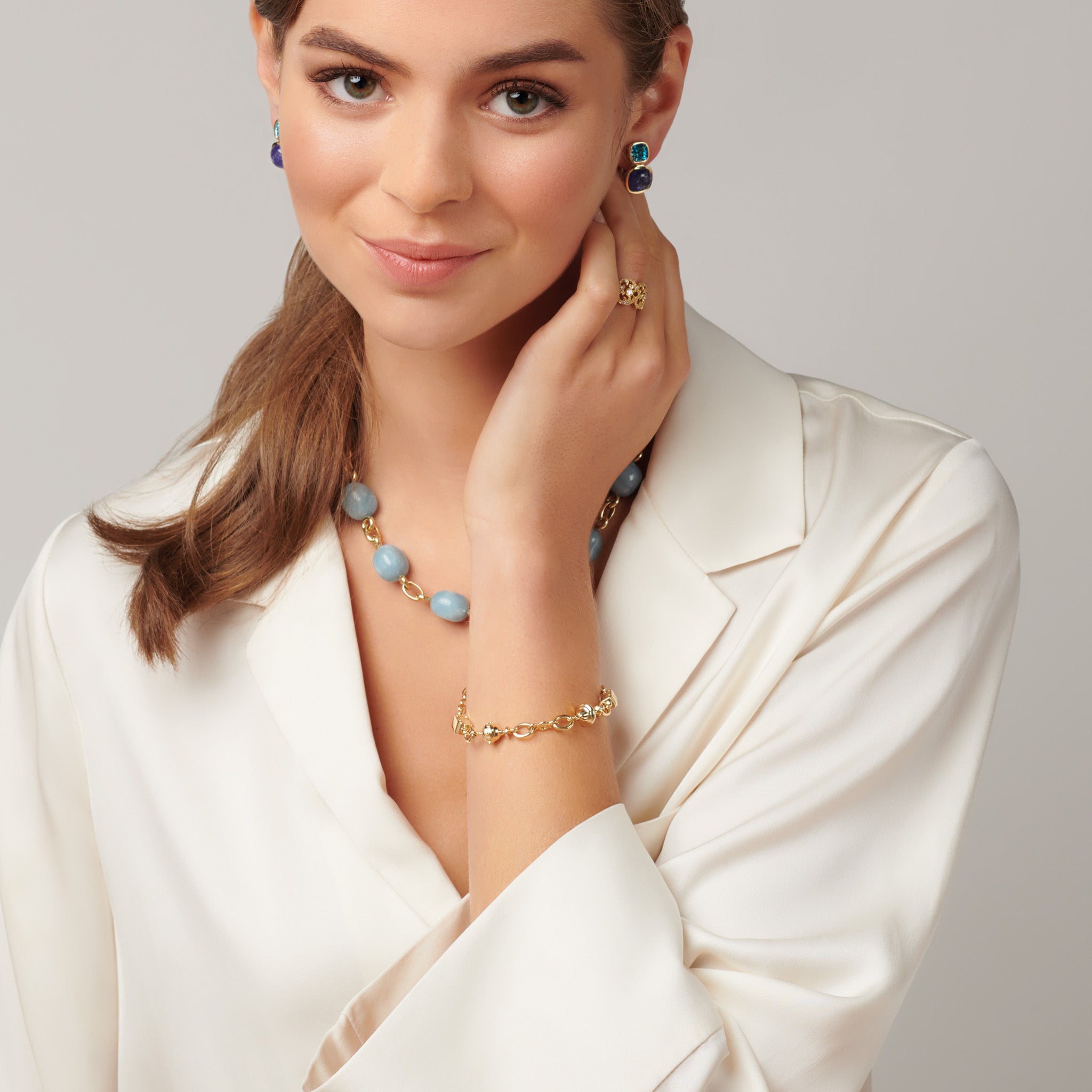 Model wearing a handcrafted yellow gold charm bracelet featuring Three Kings charms.