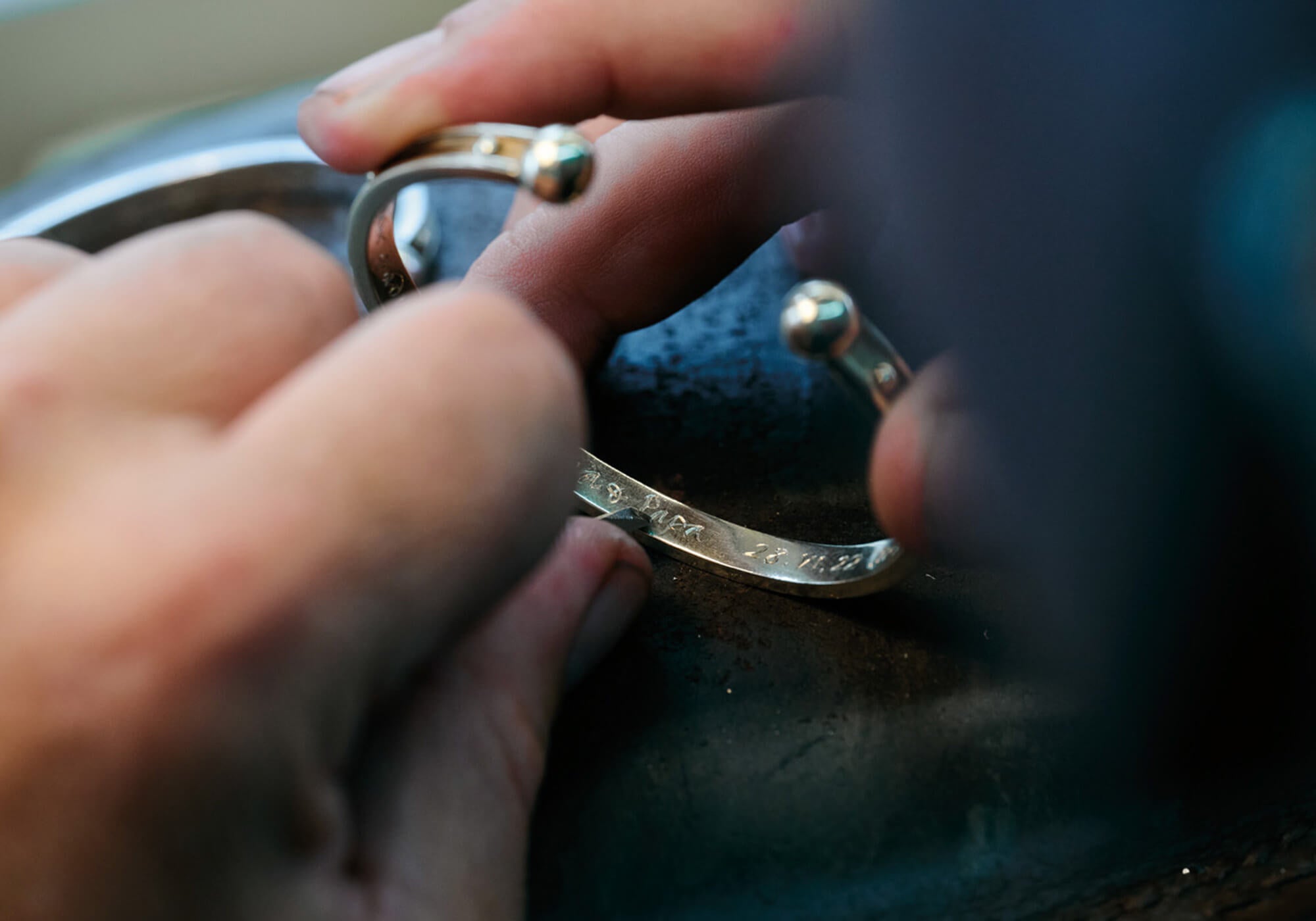 18ct yellow gold bracelet cuff being expertly hand engraved.