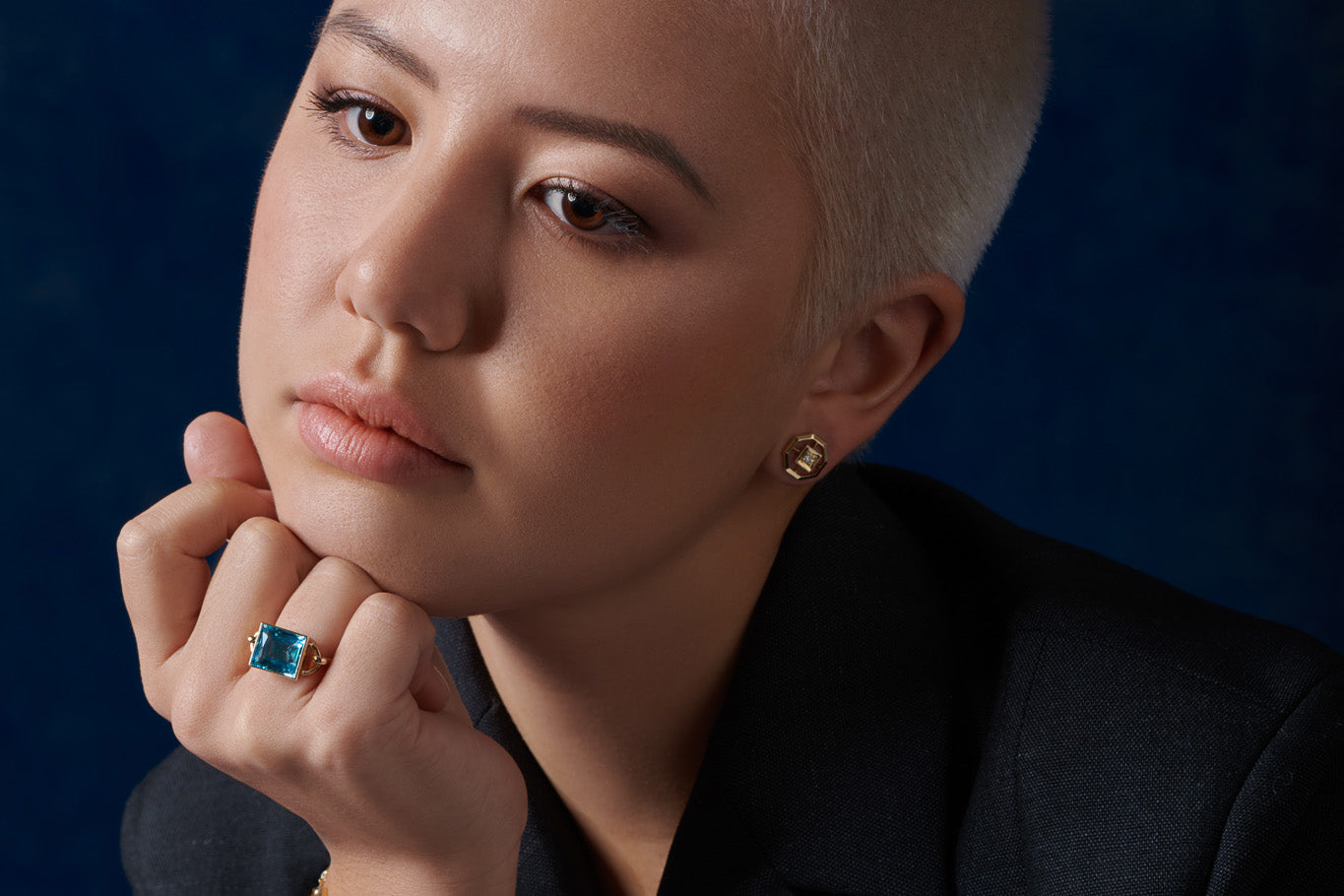 Model wearing a handcrafted yellow gold ring featuring a baguette cut aquamarine.