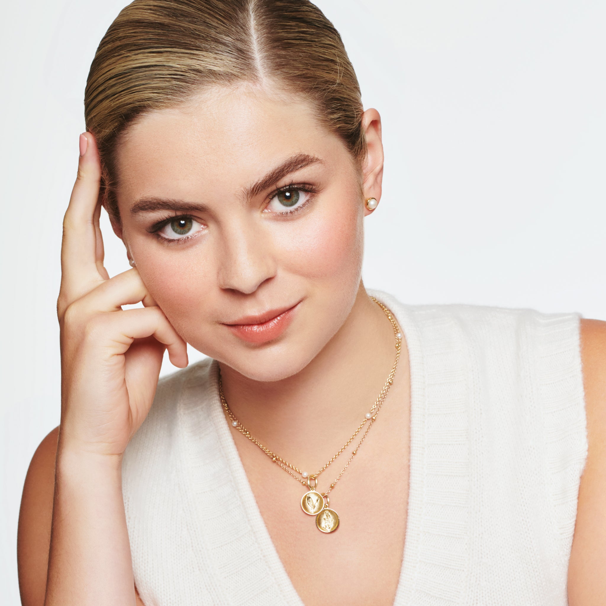 Model wearing a handcrafted round yellow gold necklace pendant 'en relief' with a buttercup flower.