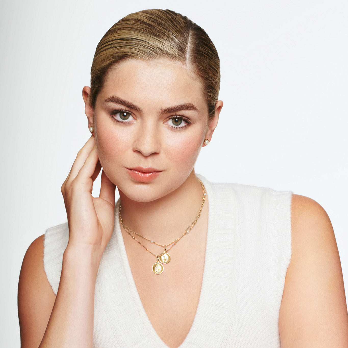 Model wearing a handcrafted yellow gold necklace pendant 'en relief' with a lily of the valley.