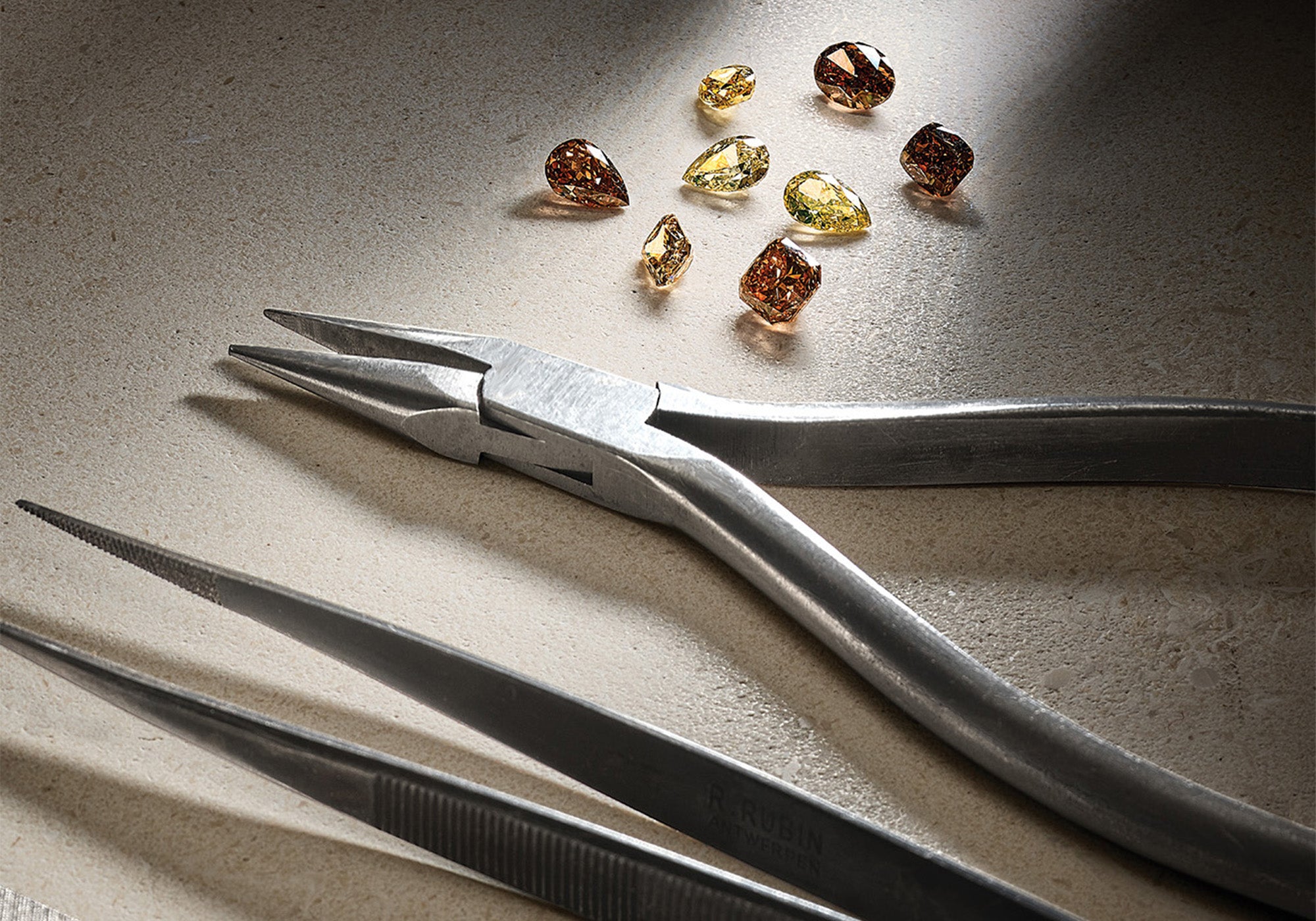 Jewellery tools next to brown and yellow precious stones