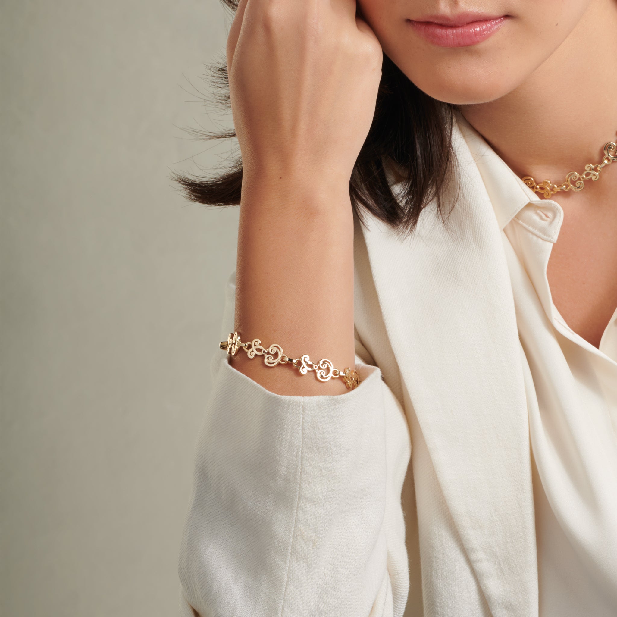 Model wearing a handcrafted yellow gold bracelet featuring ironwork motifs from the stables in France.