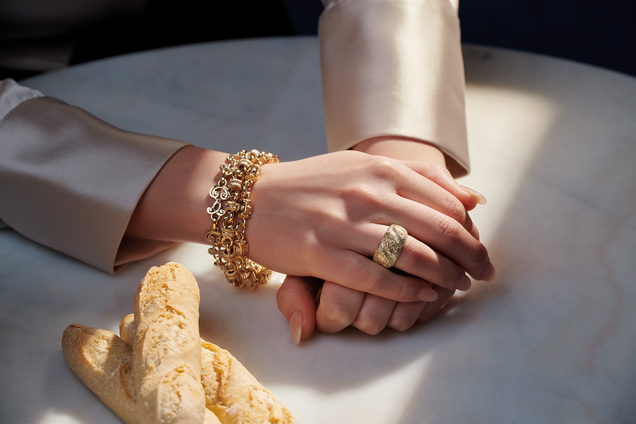 Model wearing a handcrafted yellow gold ring inspired by the French baguette.