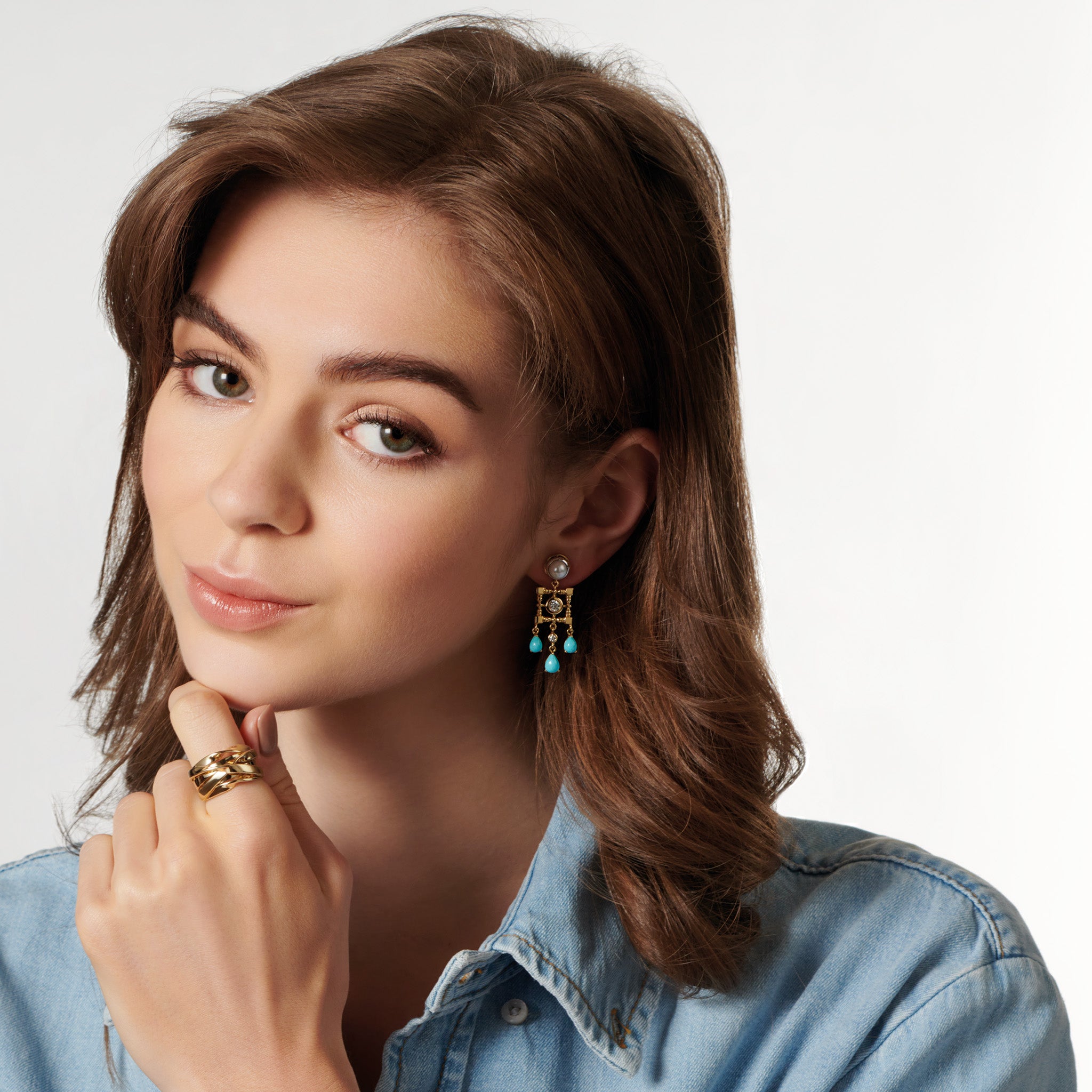 Model wearing handcrafted halo earring drops in precious metal featuring a teardrop-shaped design with precious stones.