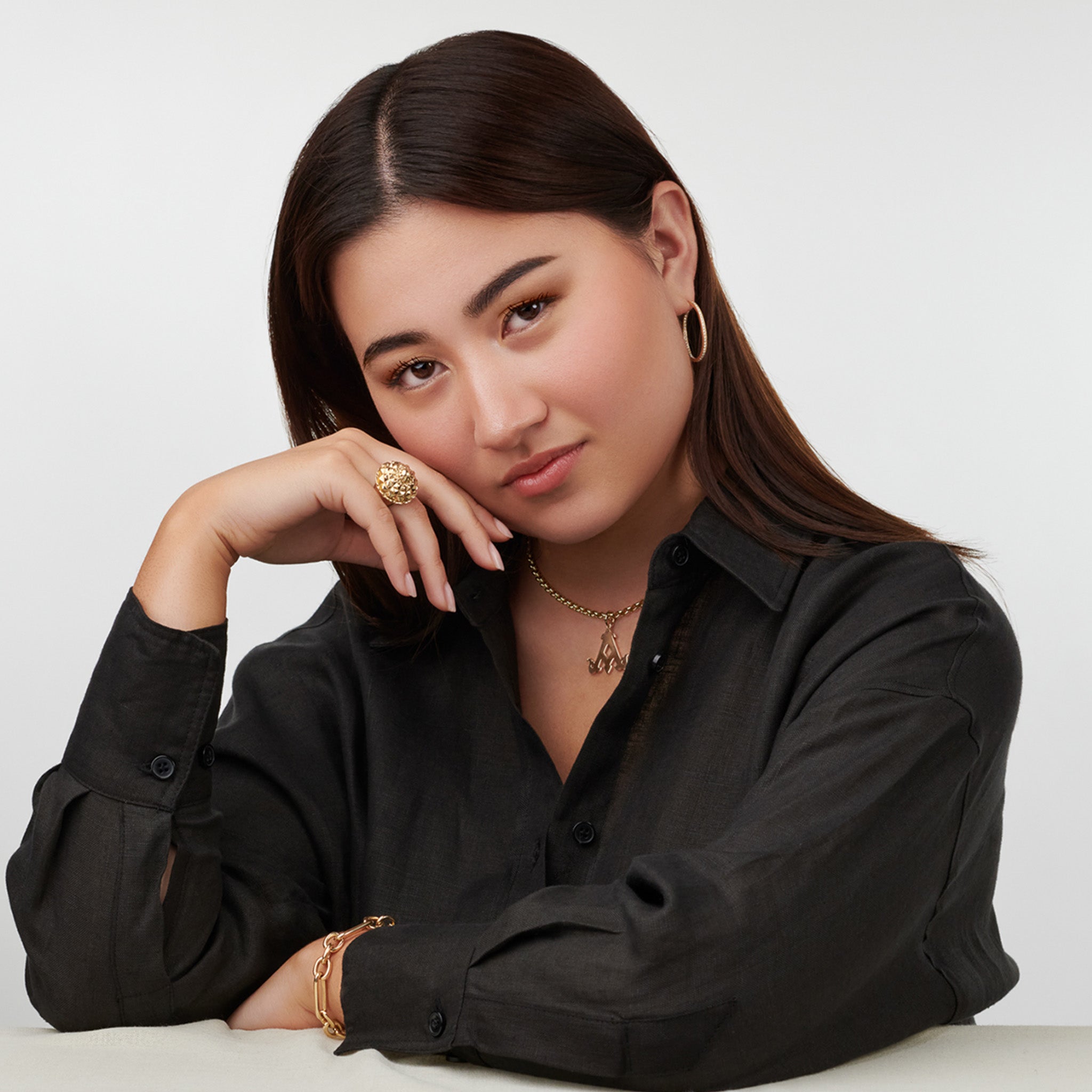 Model wearing a handcrafted yellow gold ring featuring a pineapple shape.