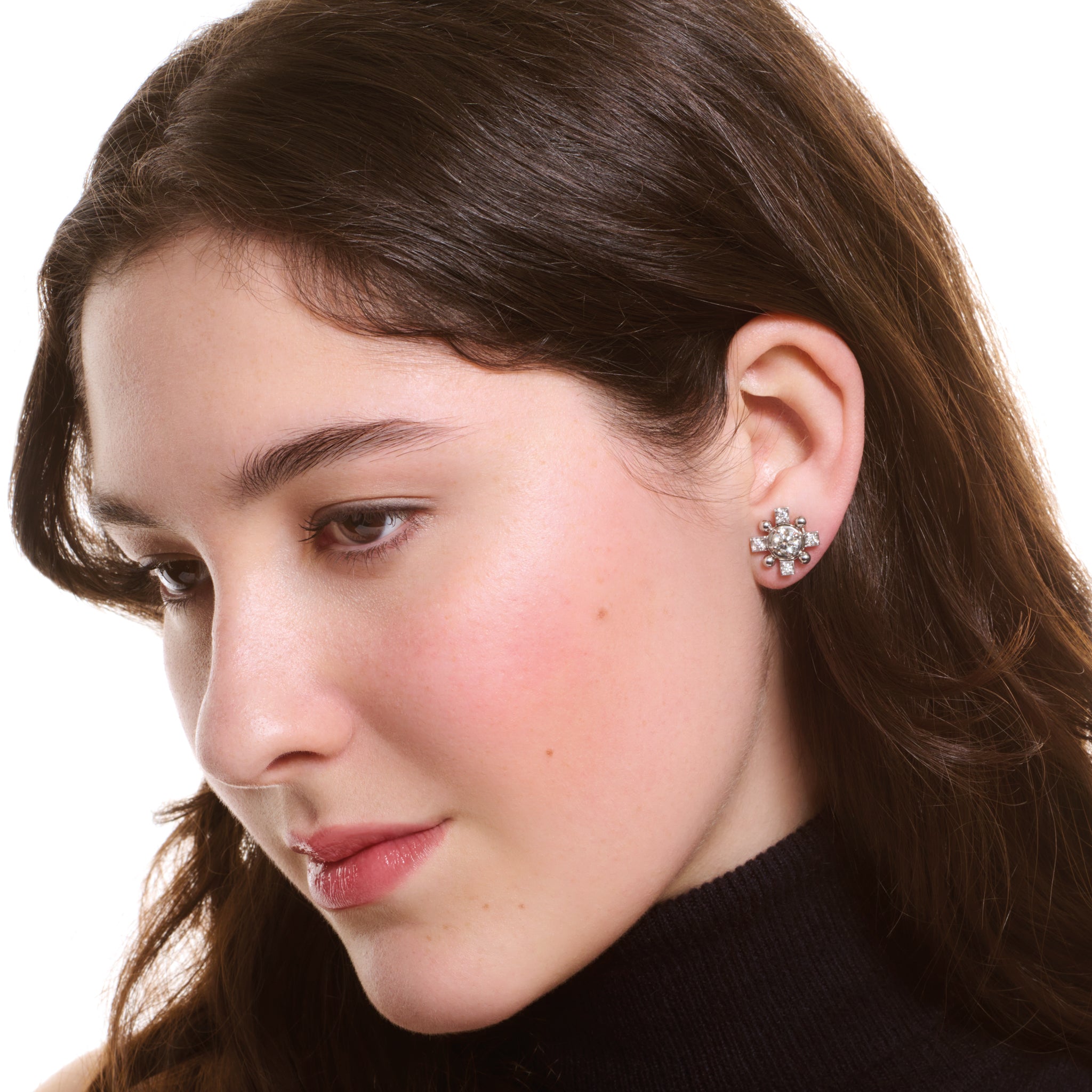 Model wearing handcrafted white gold cross shaped earring halos with diamonds.
