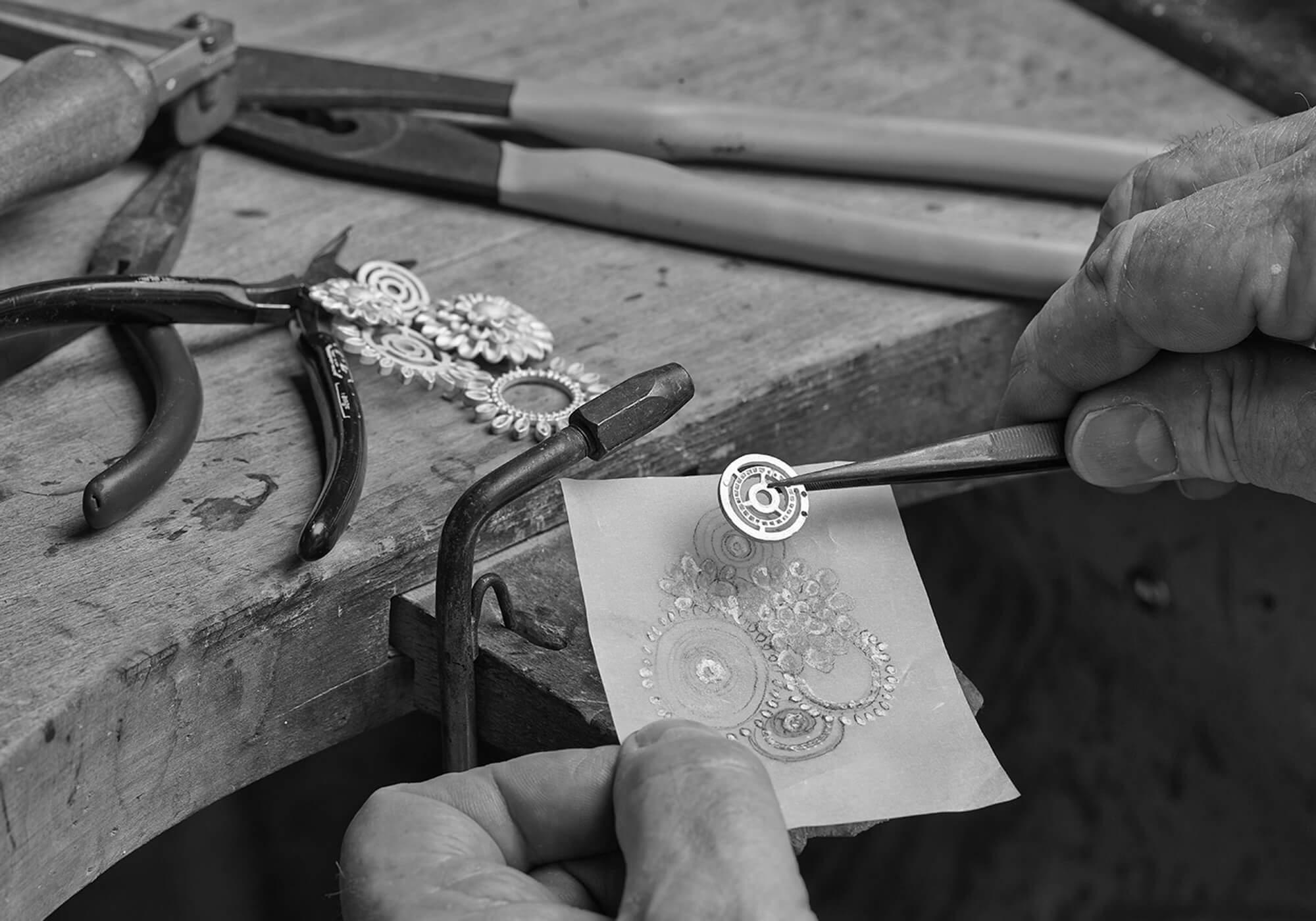 Black and white image of an earring being restored and repaired in a London workshop.