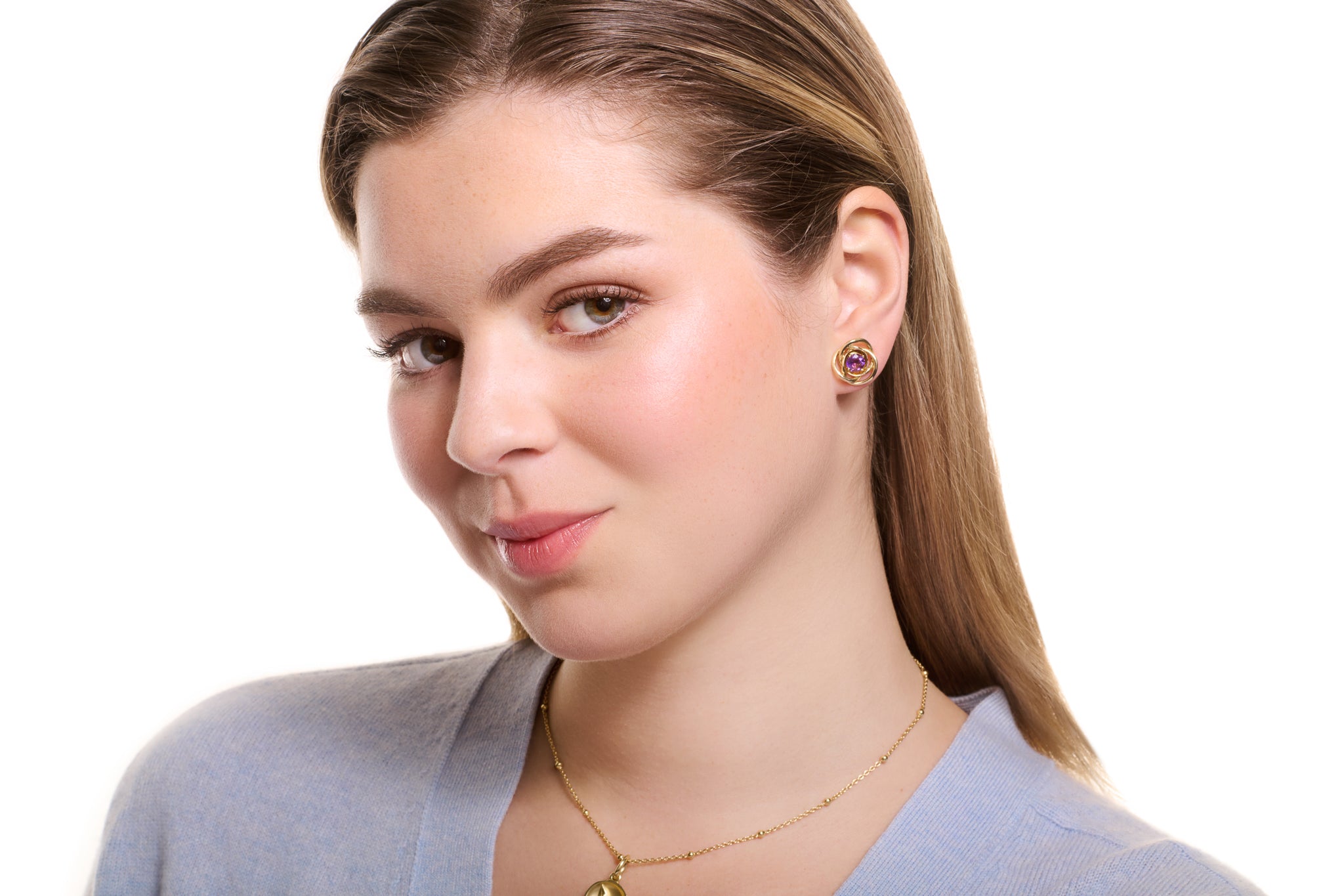 Model wearing handcrafted yellow gold earring halos featuring three overlapping circles with amethyst stud earrings at the centre, birthstone of February.