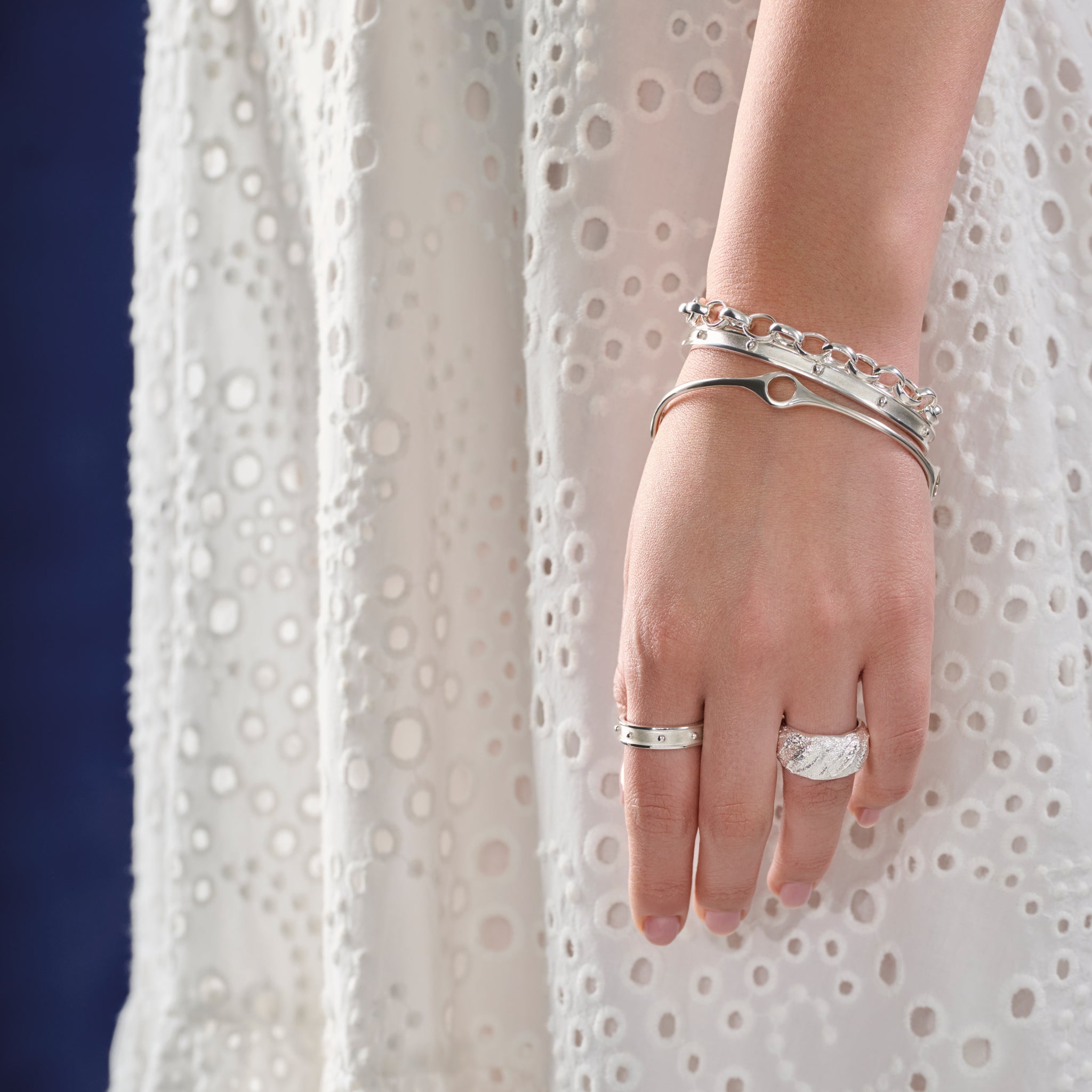 Model wearing a handcrafted sterling silver bracelet cuff with evenly spaced, protruding round dots.