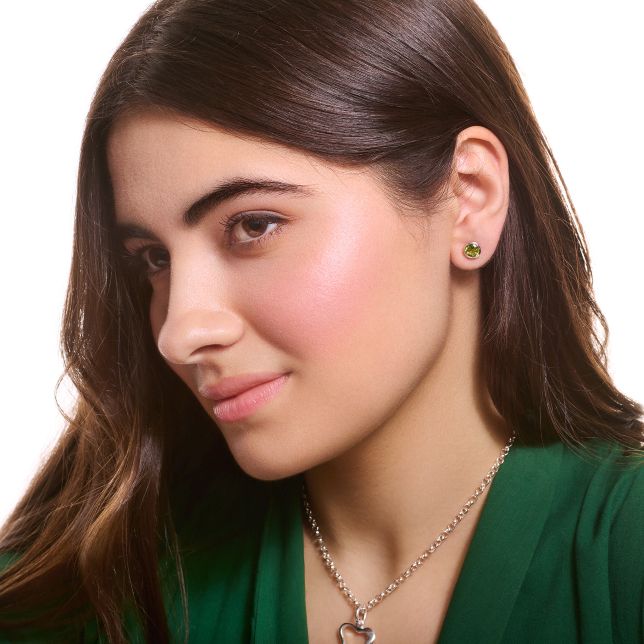 Model wearing handcrafted stud earrings in white gold featuring round peridot.