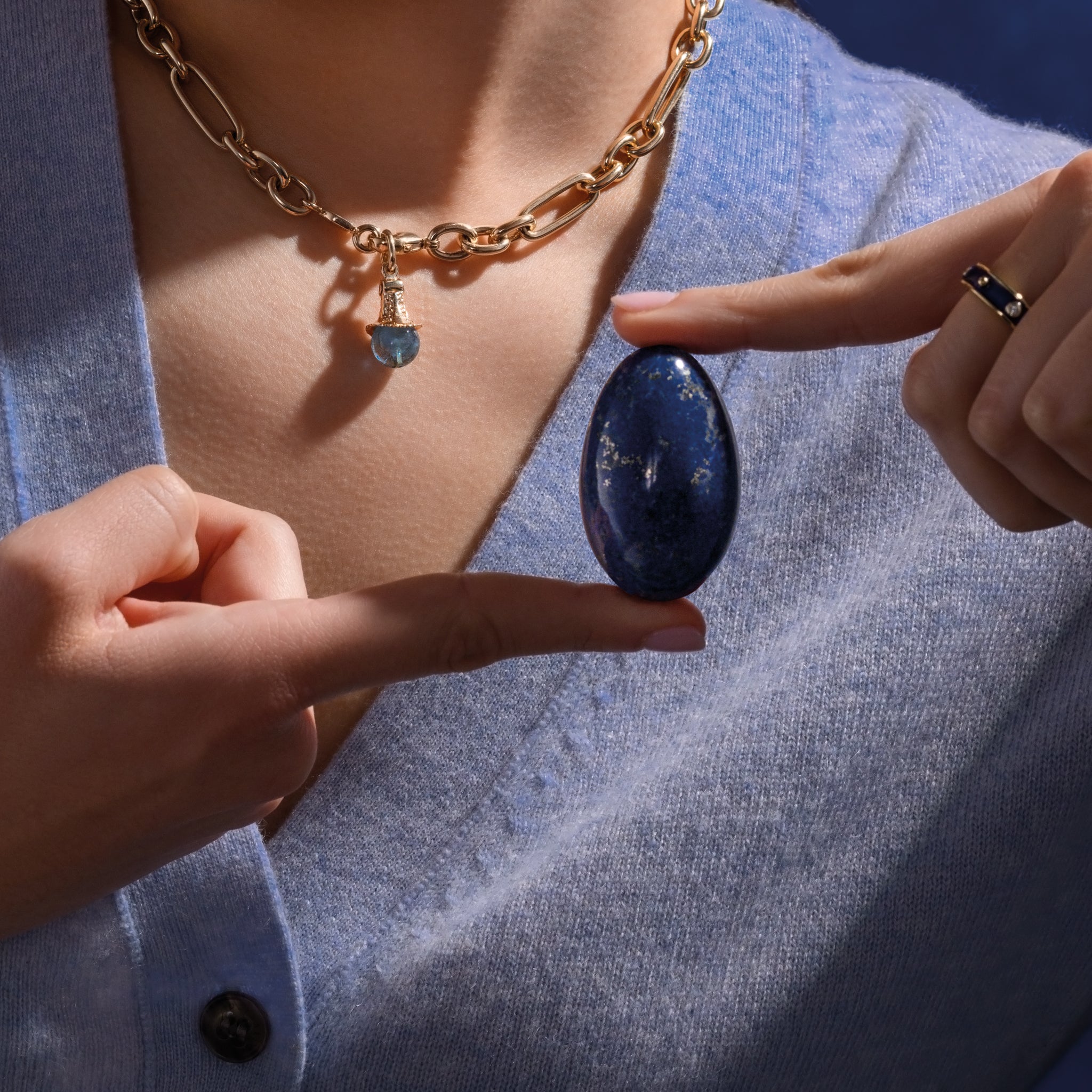 Model holding a handcrafted gemstone egg in the precious stone lapis lazuli. 