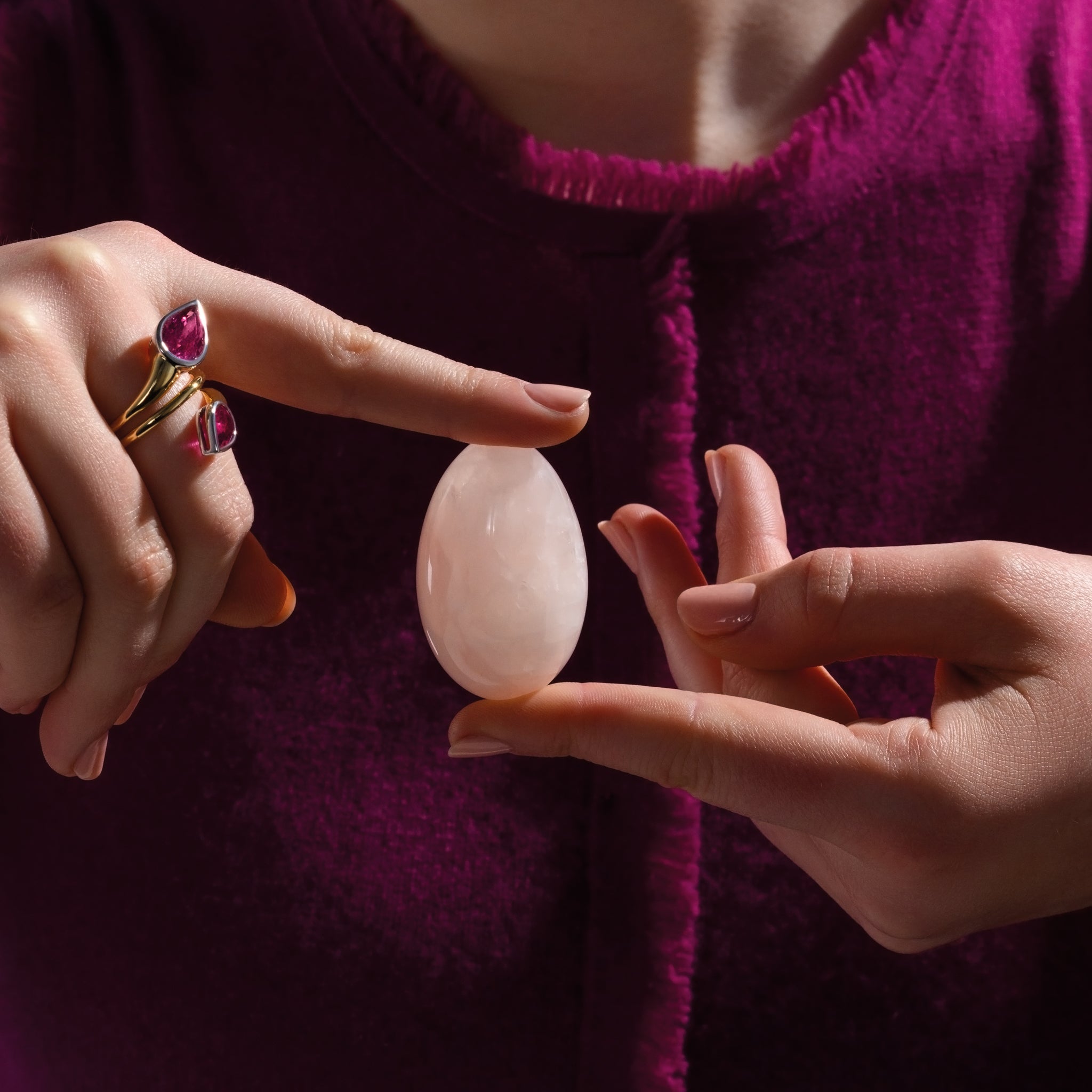 Model holding a handcrafted gemstone egg in the precious stone rose quartz. 