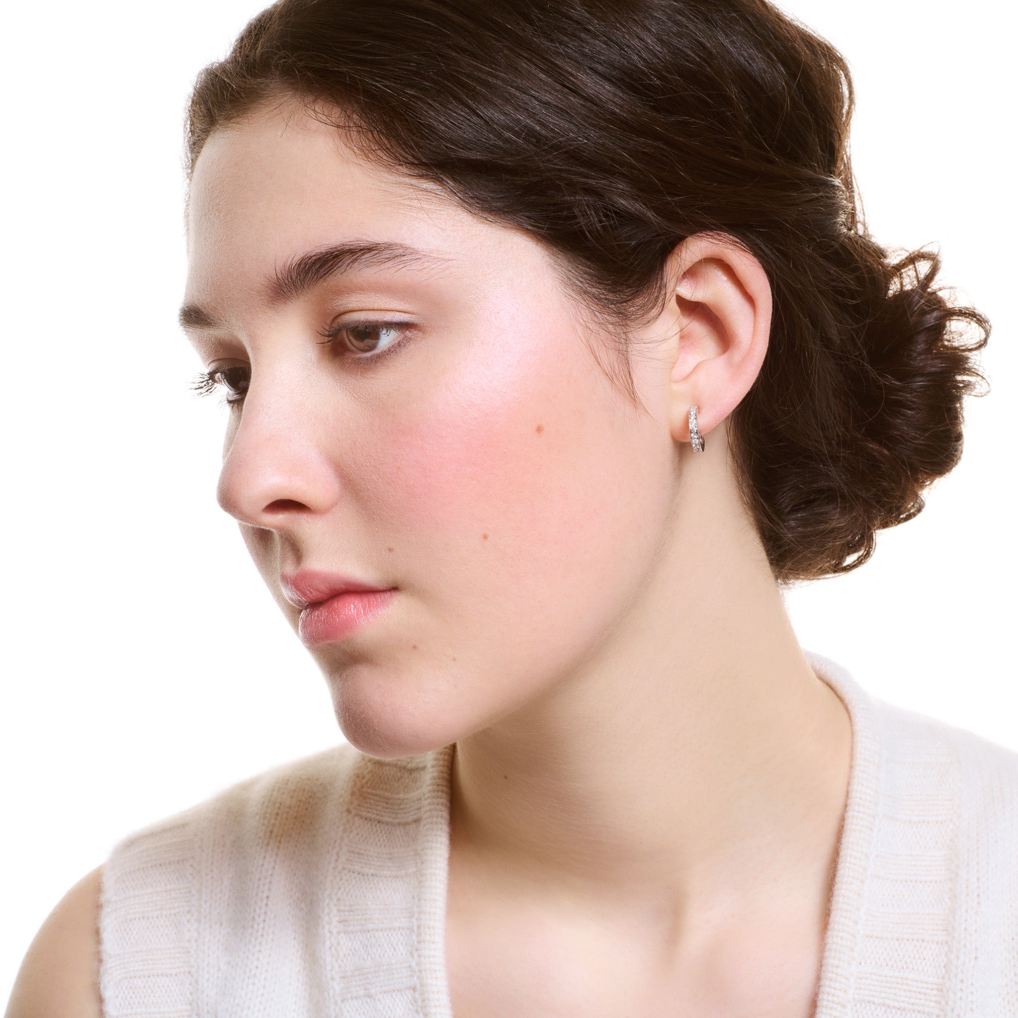 Model wearing a handcrafted 18ct white gold hoop earring set with small diamonds.